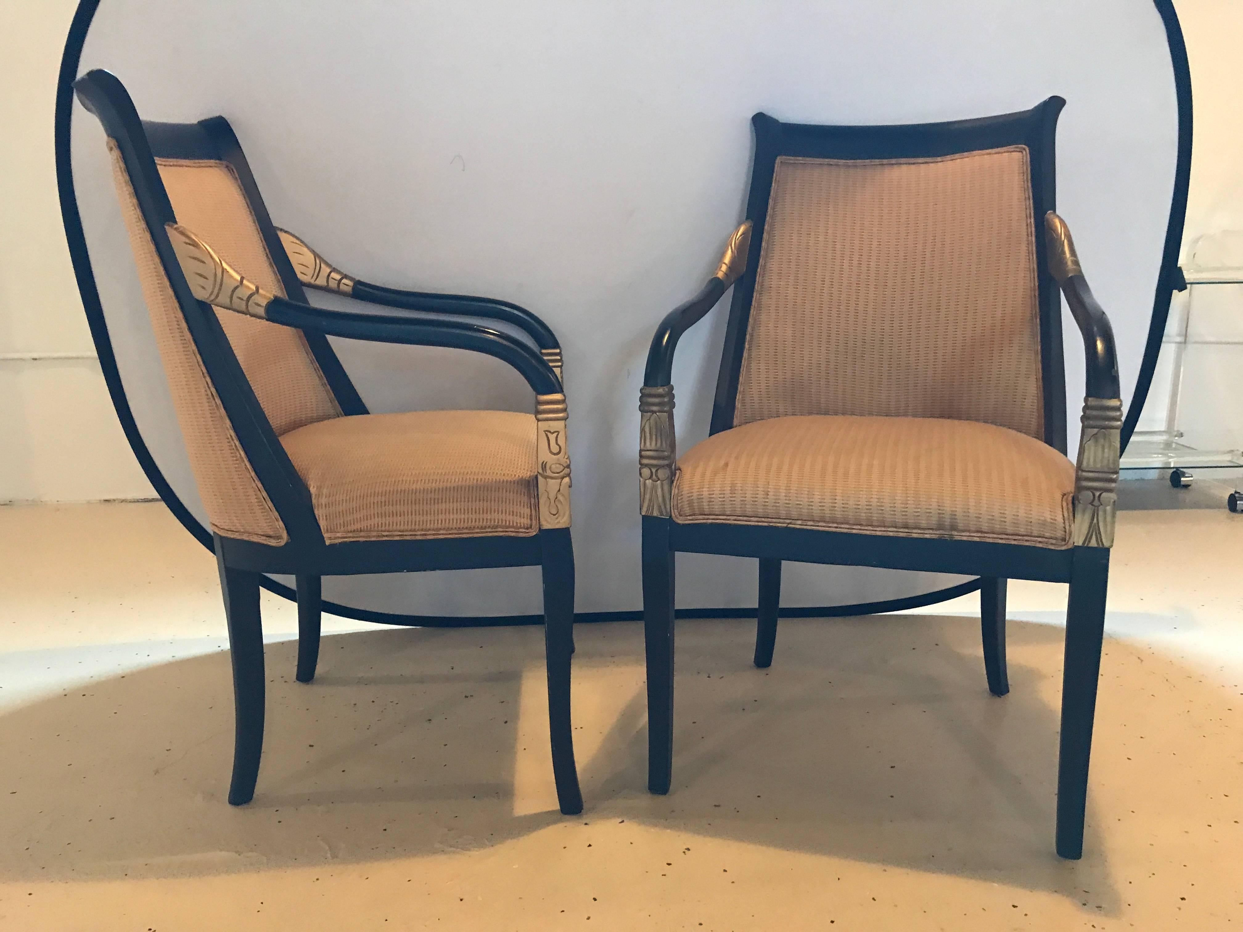 A pair of Grosfeld House armchairs ebony and gilt decorated. Each on curved tapering legs supporting a padded seat with gilt decorated hand and upper arm rests. These sleek and stylish arm chairs or fauteuils would make a lovely addition to any