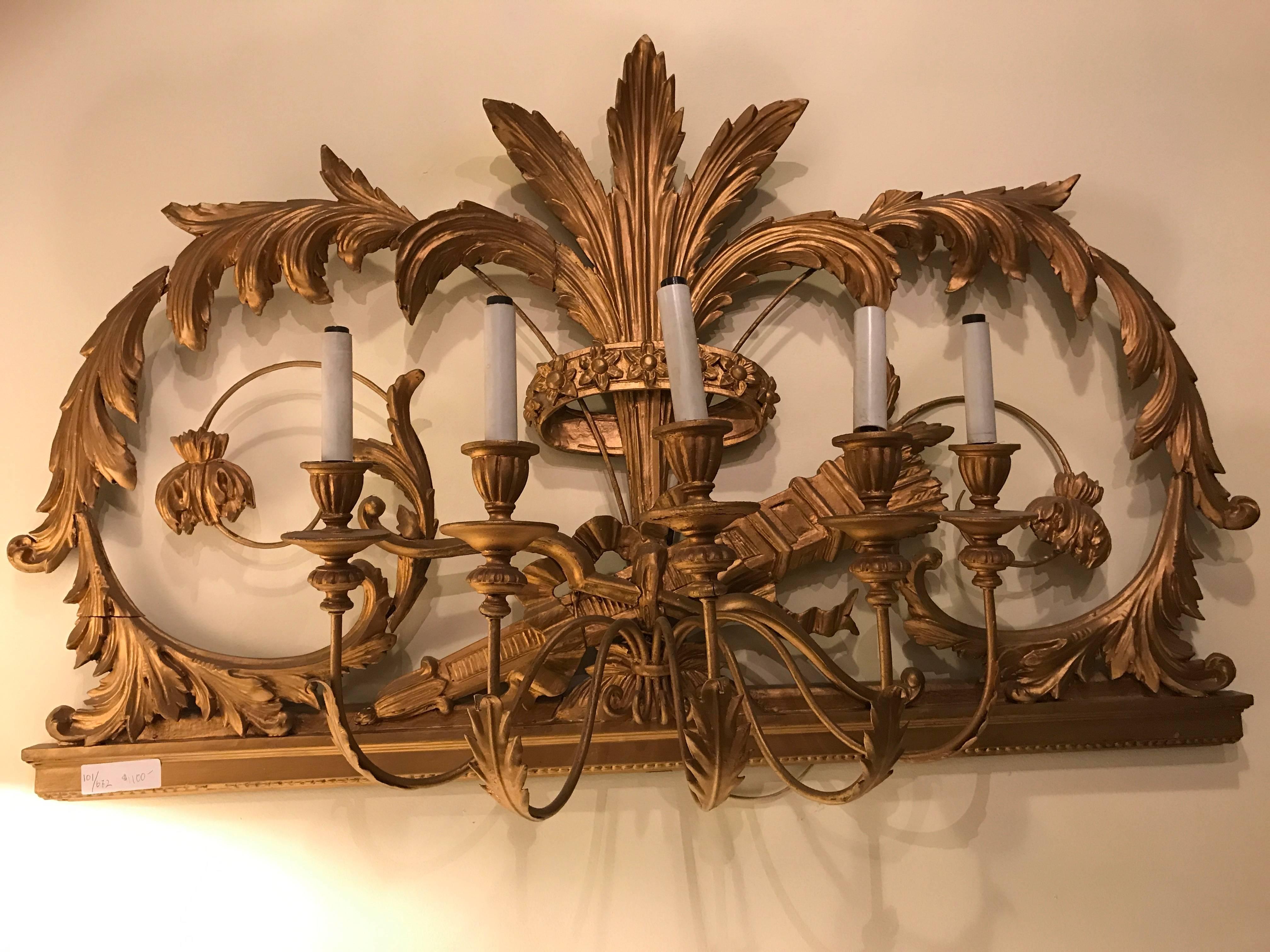 Italian five light gilt gesso wall sconce. This is a simply fantastic wall sconce decoration. The wonderfully carved decorative wall mount has a crown centered by leafs and vines of gilt gold with five lighted arms coming forward. This highly