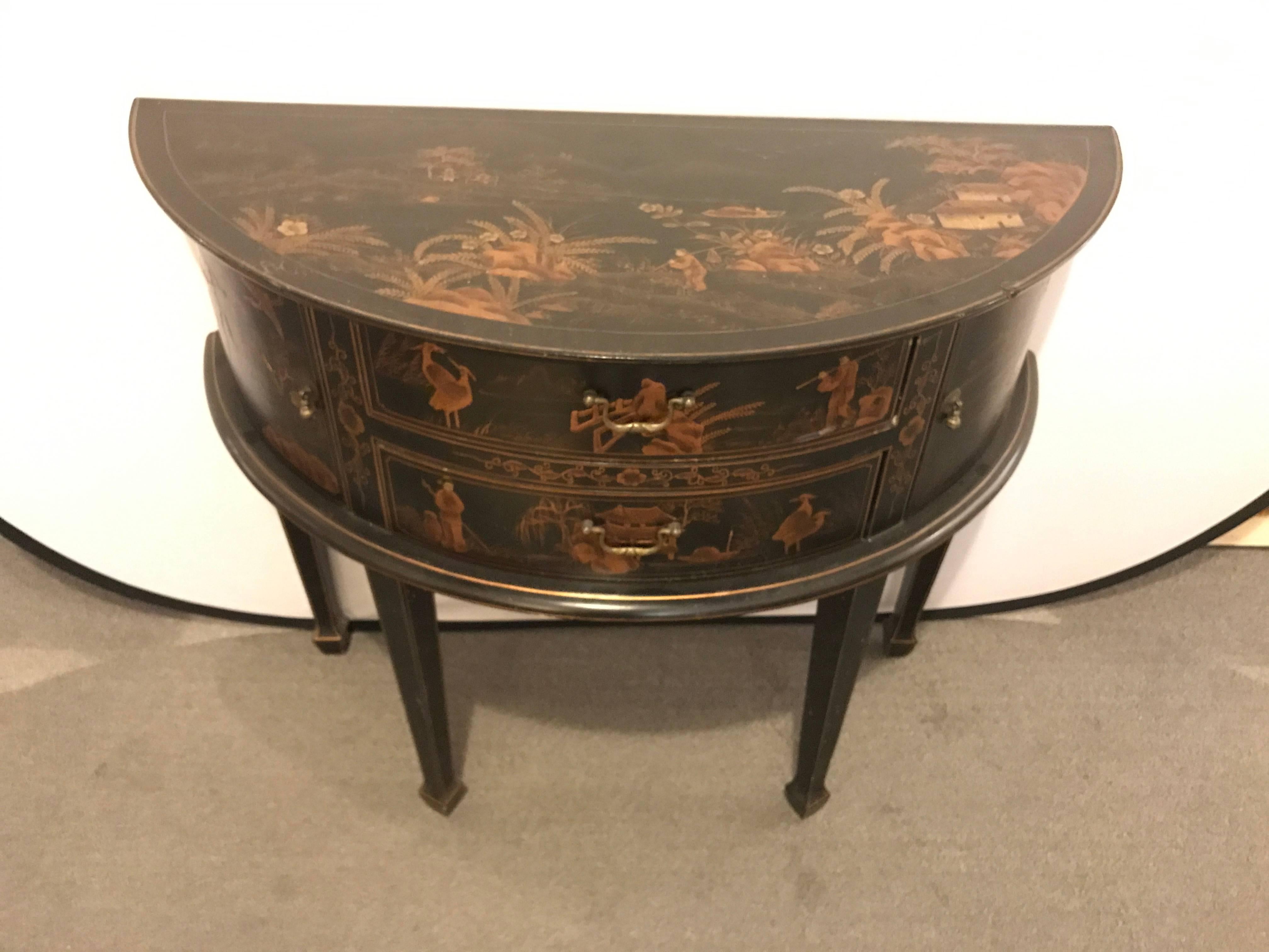 Chinoiserie decorated demilune server or chest. A small demilune with fine paint decorated scenes on an ebonized background. Sitting on tapering legs and sabots.