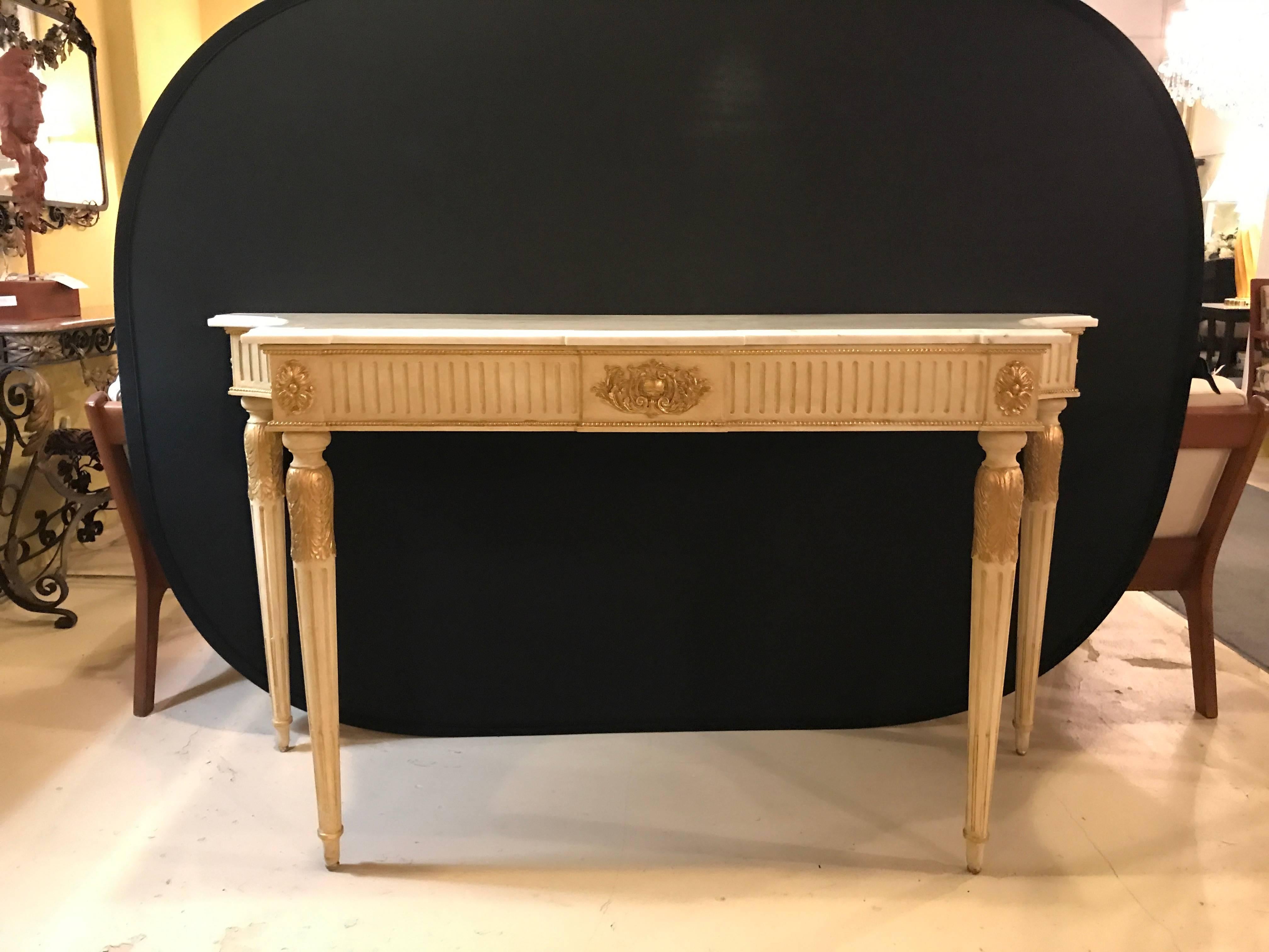 This fine Hollywood Regency style console - sofa table with marble top has been fashioned in the Maison Jansen - Louis XVI style. With inverted curved sides and in a parcel-gilt and paint decorated finish this finely constructed console table is