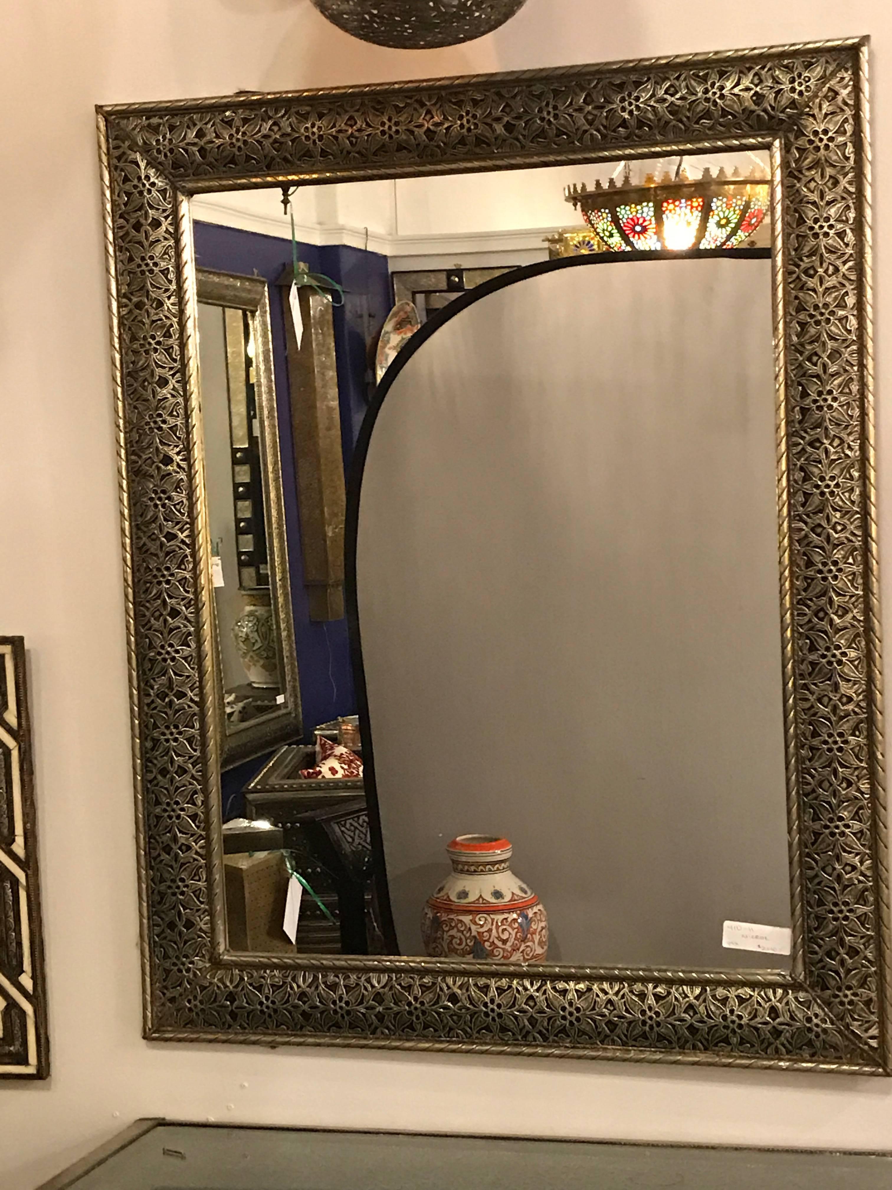 This Moorish mirror is hand-carved with filigree-style details on silver metal. Guaranteed to make a bold aesthetic statement, this mirror is a wonderful addition to any living space. 1HXX