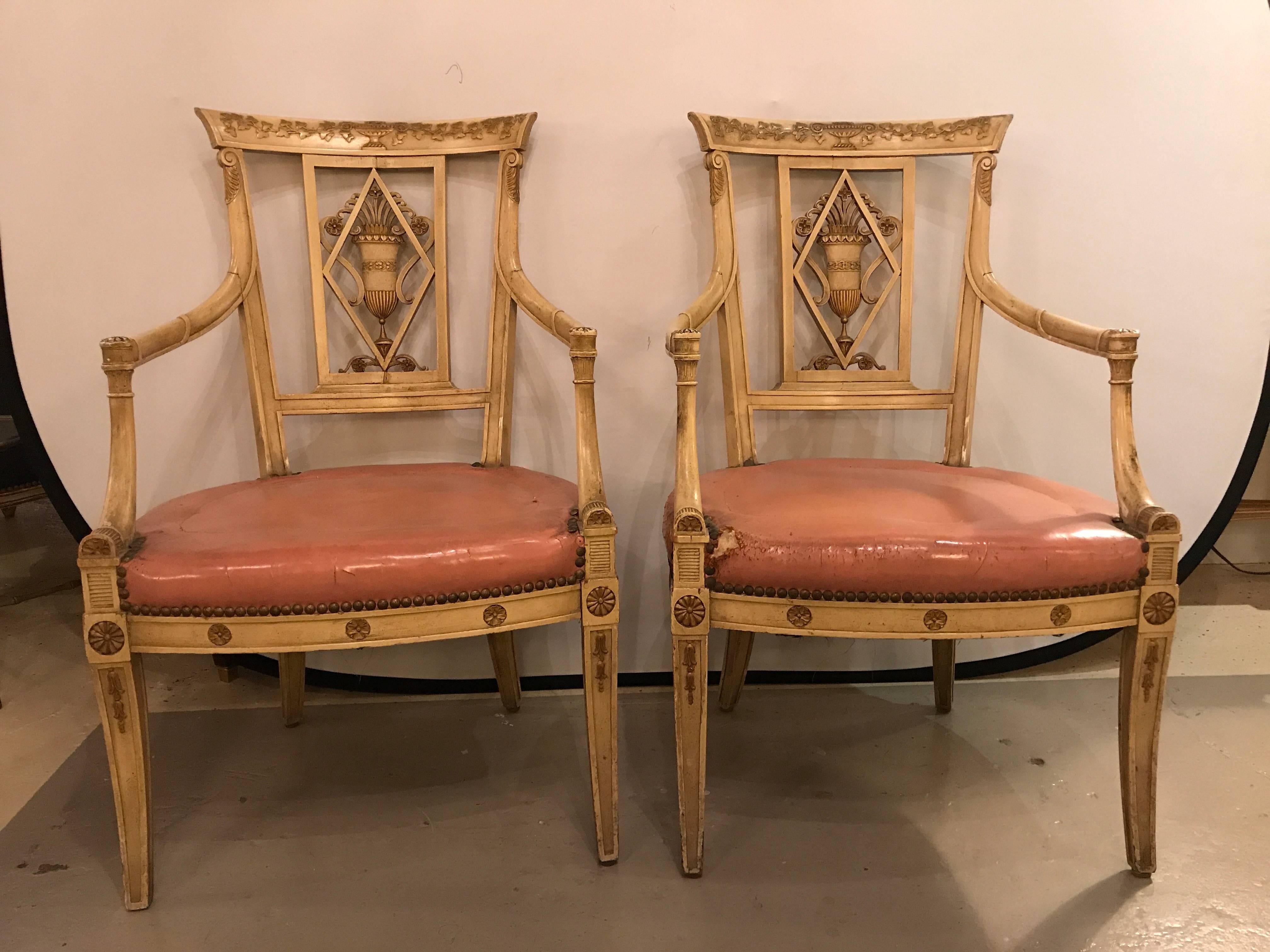 Having a Salmon colored padded seat come this finely detailed pair of Fauteuils by this highly sought after designer. The beige off-white colored frame with a backrest having a carved urn in the centre. The top of the backrest depicts an urn with