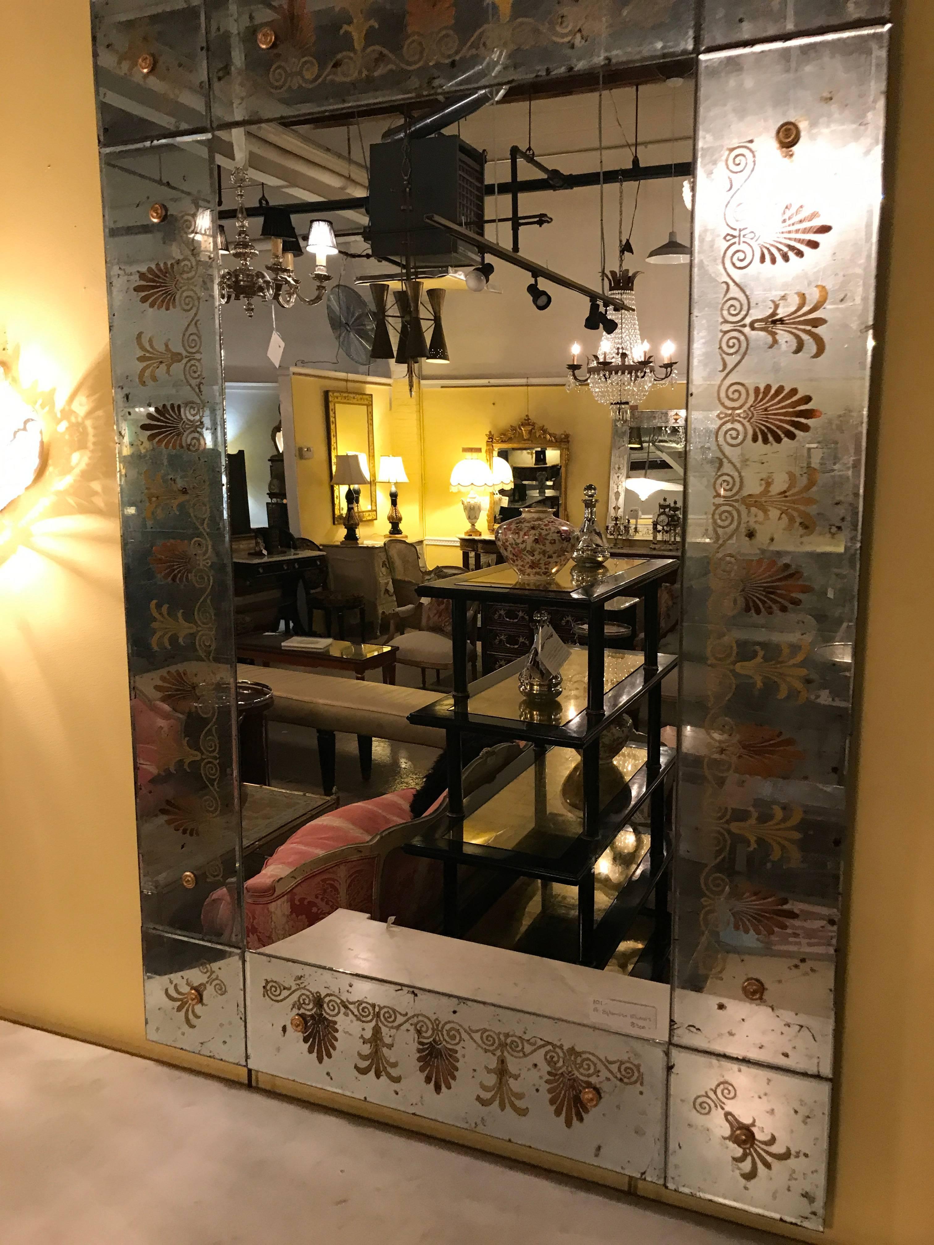 A pair of Maison Jansen églomiséd framed mirrors. Pair of gorgeous Venetian style Verne églomisé glass mirrors, the framed bordered with beautiful reverse painted scrolls, foliage, and floral detail flanking a mirror. Attributed to Maison Jansen.