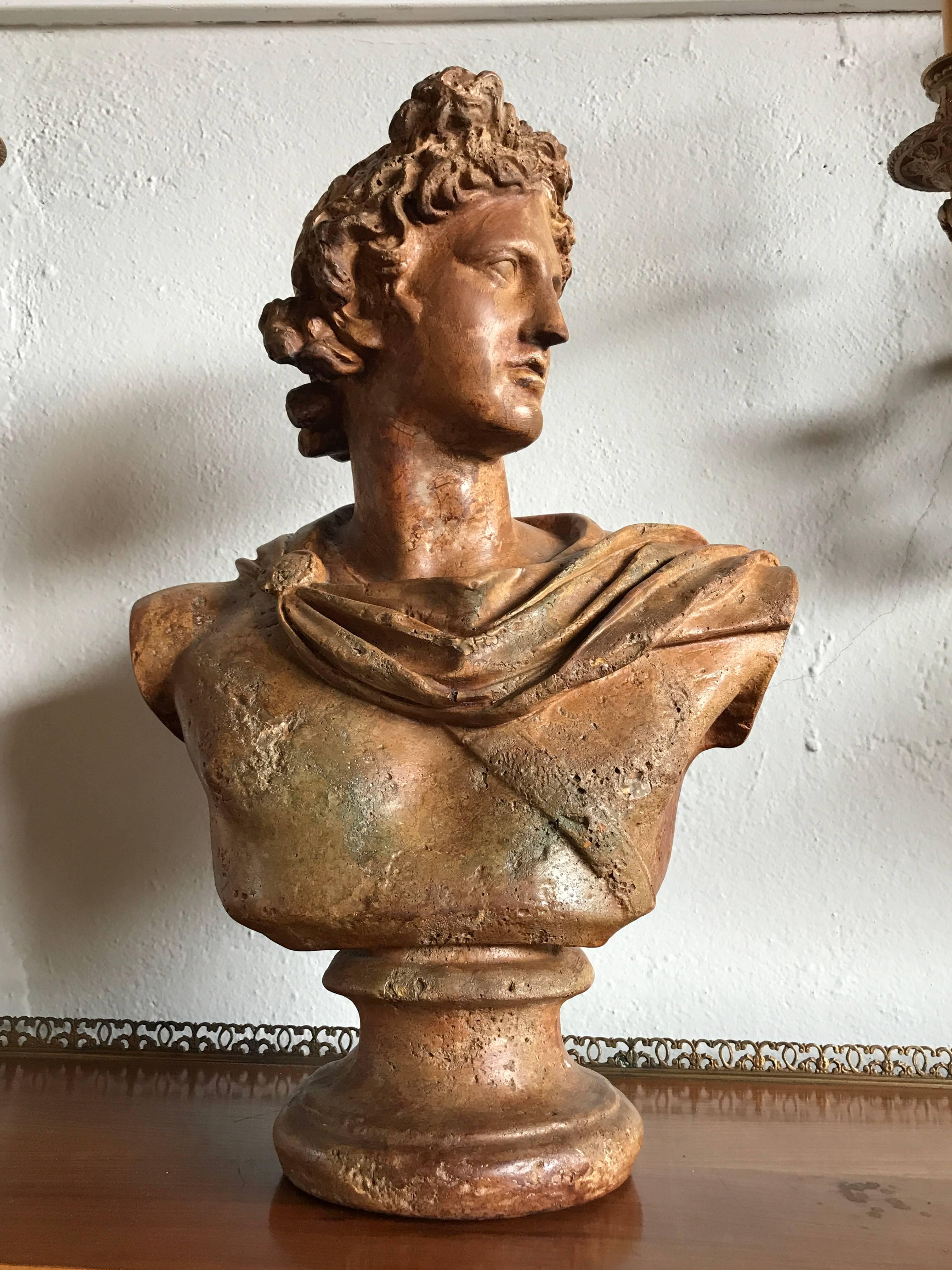An antique bust of A Greek God. The weathered and worn bust having all the markings of fine antique sculpture. Wonderful detail and design.