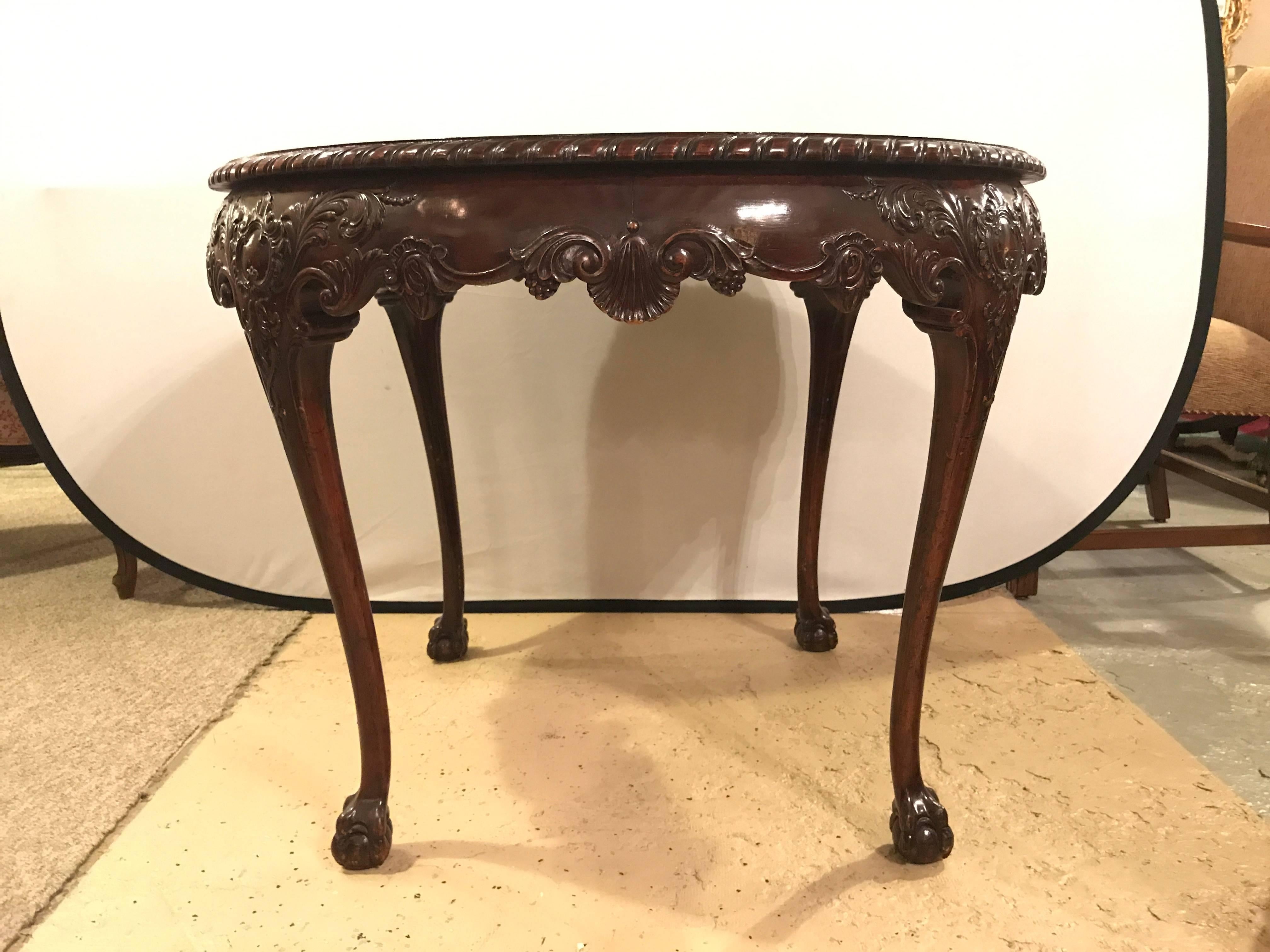 Georgian Style Centre table, circular on ball and claw feet with cabriole legs. The scalloped edged top supported by a carved apron of shell and floral design with curved legs leading to ball and claw feet. Sale due to small veneer damage to top. 