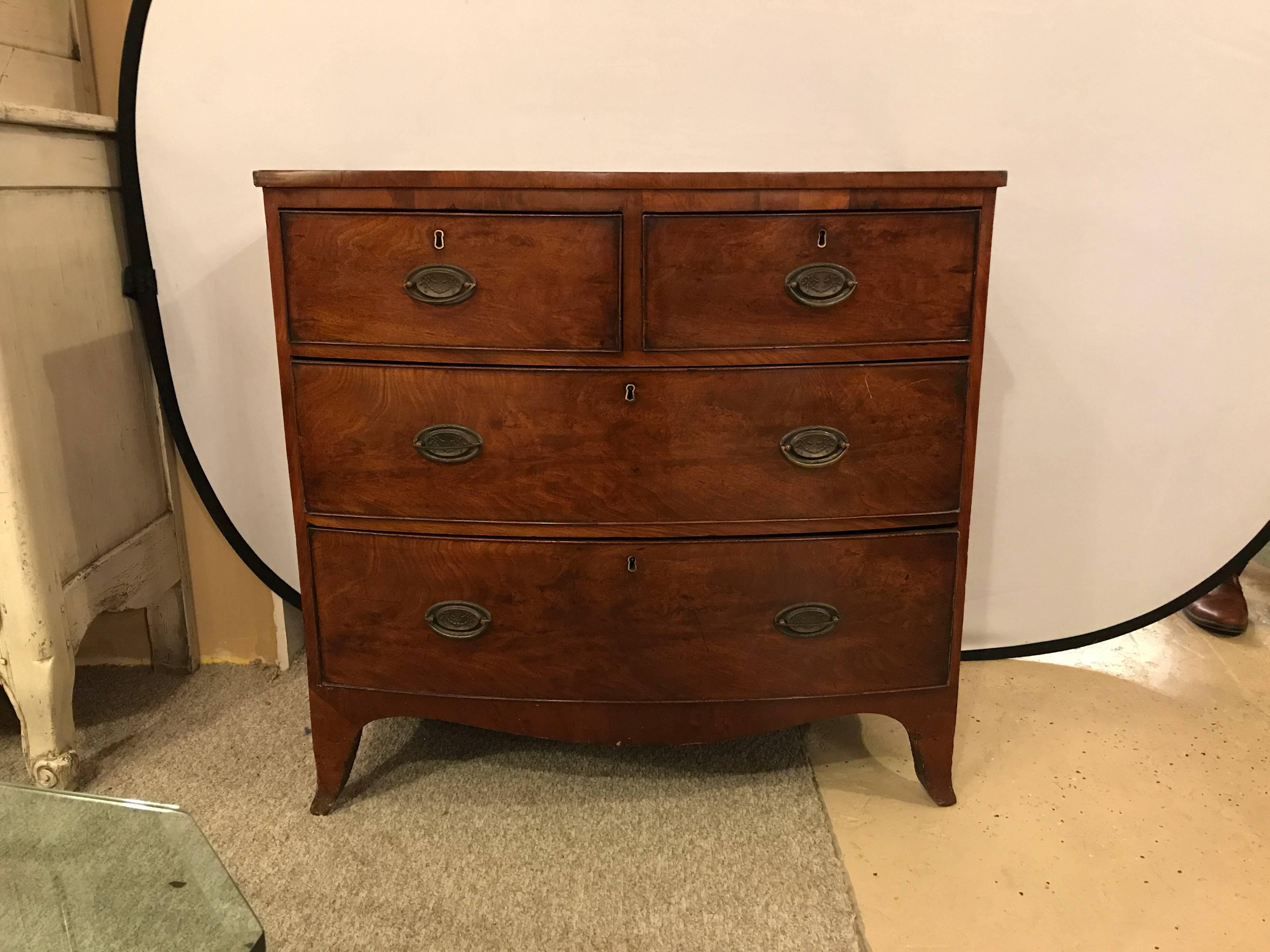 A Georgian four-drawer mahogany bachelors chest. Wonderfully early period chest having a flame mahogany top with a satinwood banding leading to a group of two over two drawers of flame mahogany with original pulls. The case itself having recently