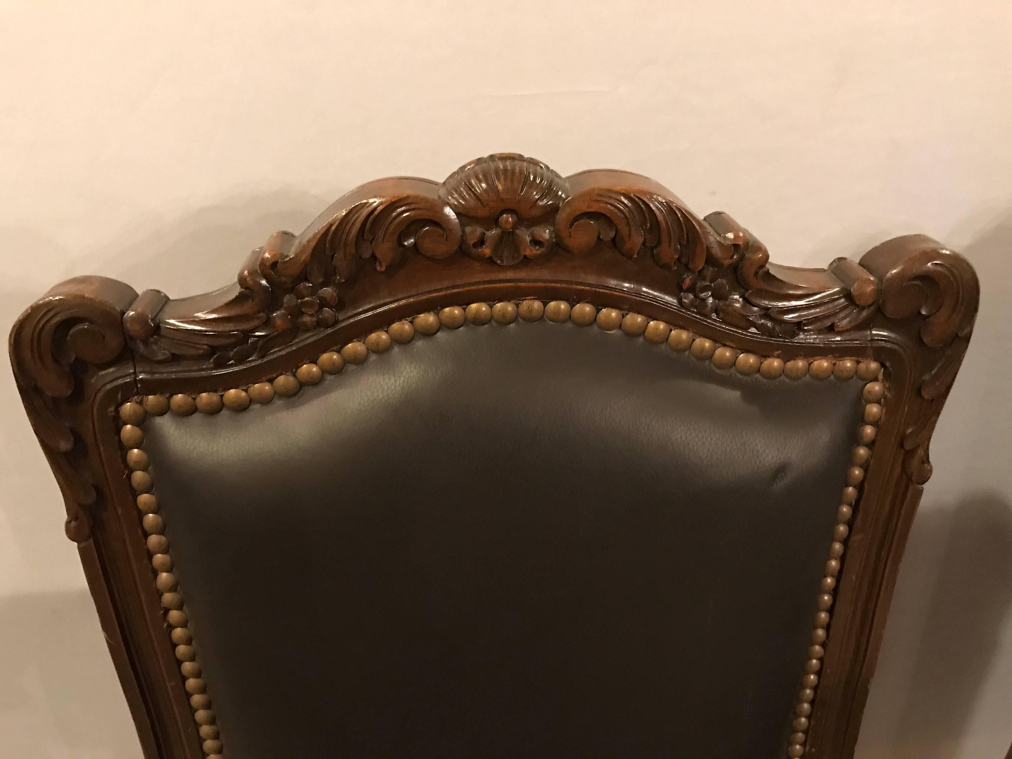 Set of six Louis XV style brown leather carved side chairs. Each having a carved cabriole leg leading to a shell carved form apron supporting high back rests with wood frames terminating in a shell motif and carved leaf and vine design. All in fine