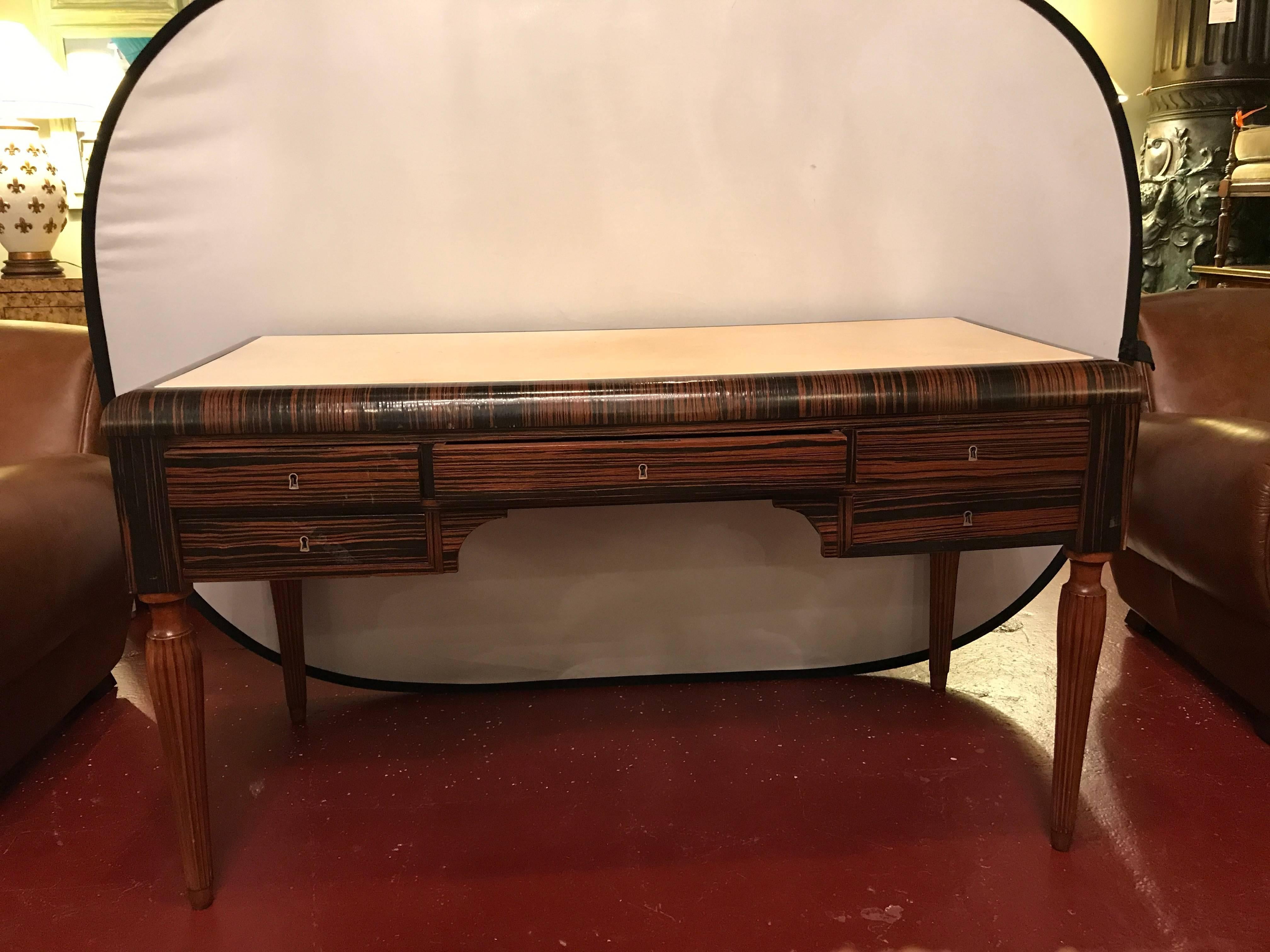 Art Deco style Masculine ebony and Macassar desk with parchment writing service. The strong tapering and reeded legs supporting a parchment writing service over a group of paired drawers flanking a centre drawer. The whole a Fine and sleek looking