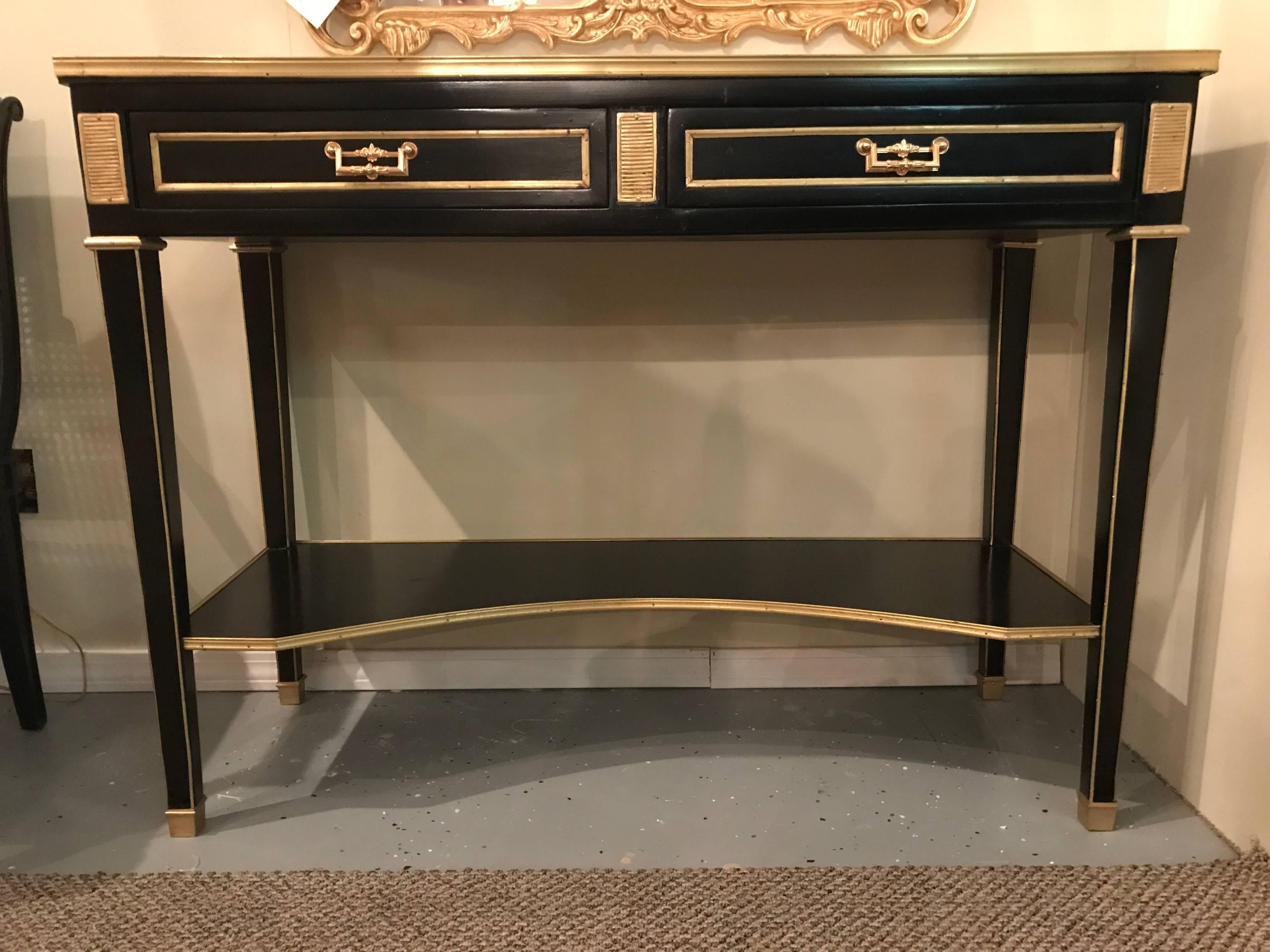 A pair of Jansen style ebonized two drawer bronze-mounted marble-top console tables. These wonderfully Russian neoclassical inspired consoles have a white and gray veined bronze galleried marble top above a pair of bronze famed drawers. The center