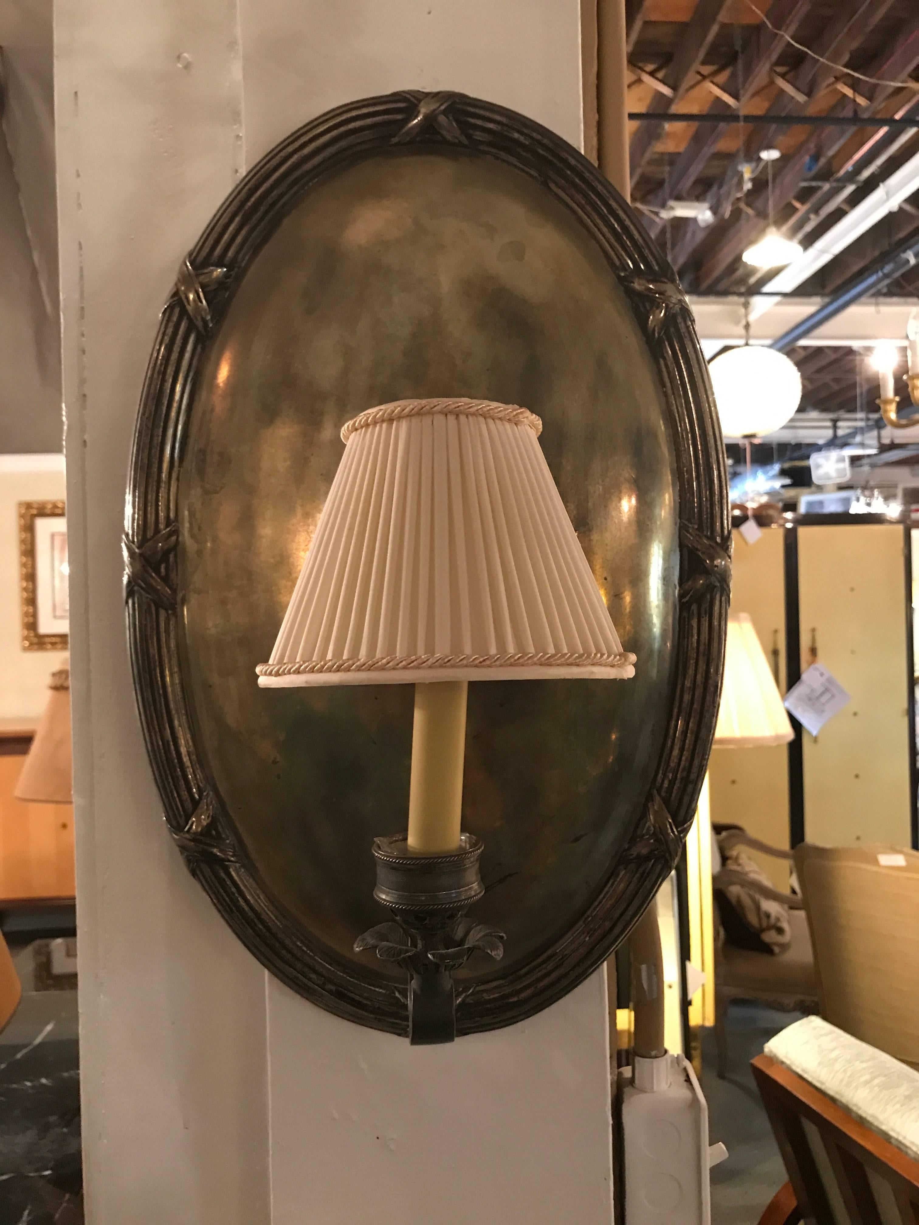 A pair of Hollywood Regency silver plate one light wall sconce. Each single light wall sconce on a solid silver place with X-form designed reeded framing. Wonderfully constructed having a fine aged patina.