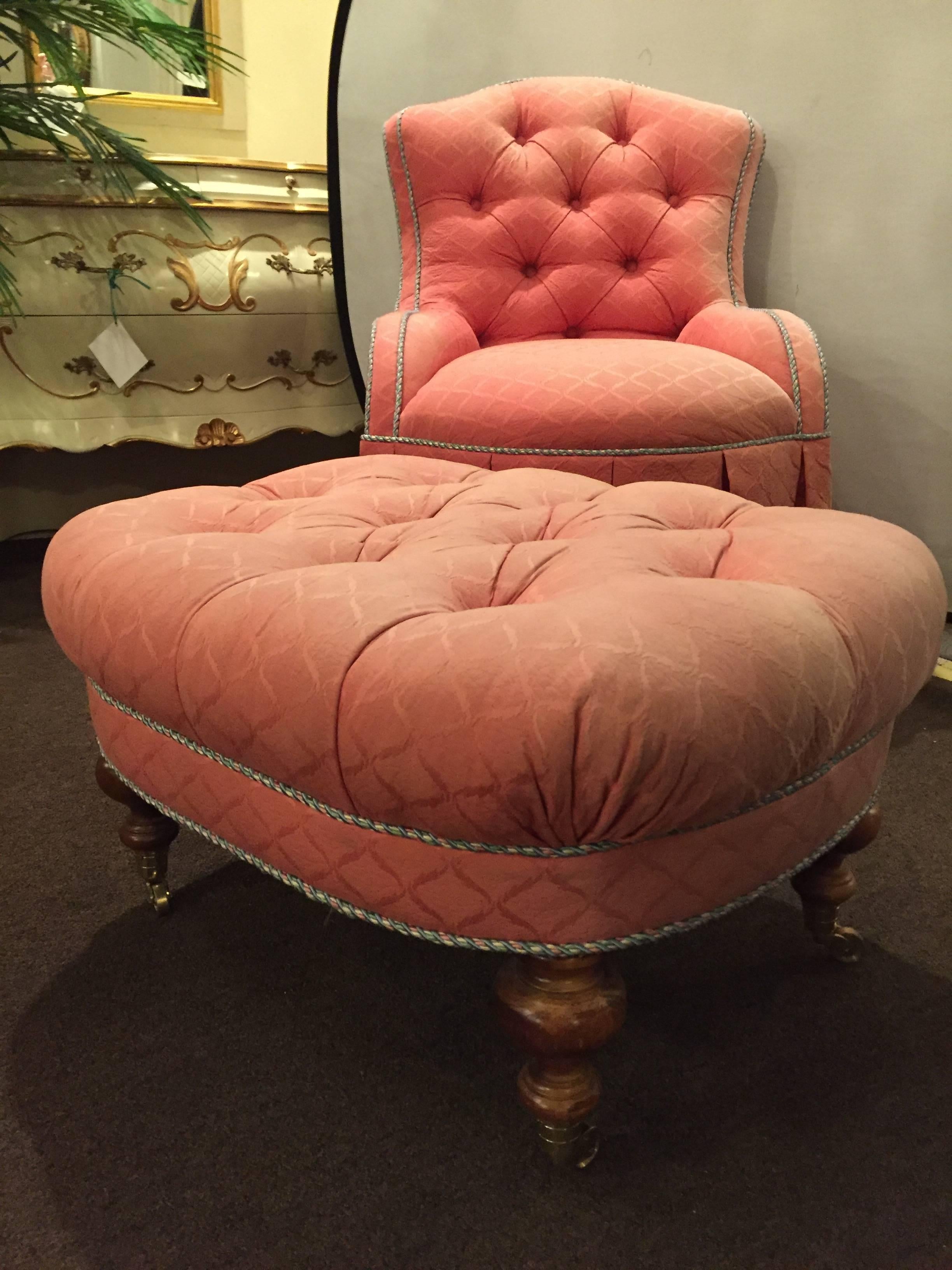 A finely upholstered custom quality slipper chair with matching ottoman. Having a tufted backrest and footrest this decorative chair and ottoman set are sure to add style and flair to any room in the house. The whole sitting on brass casters with