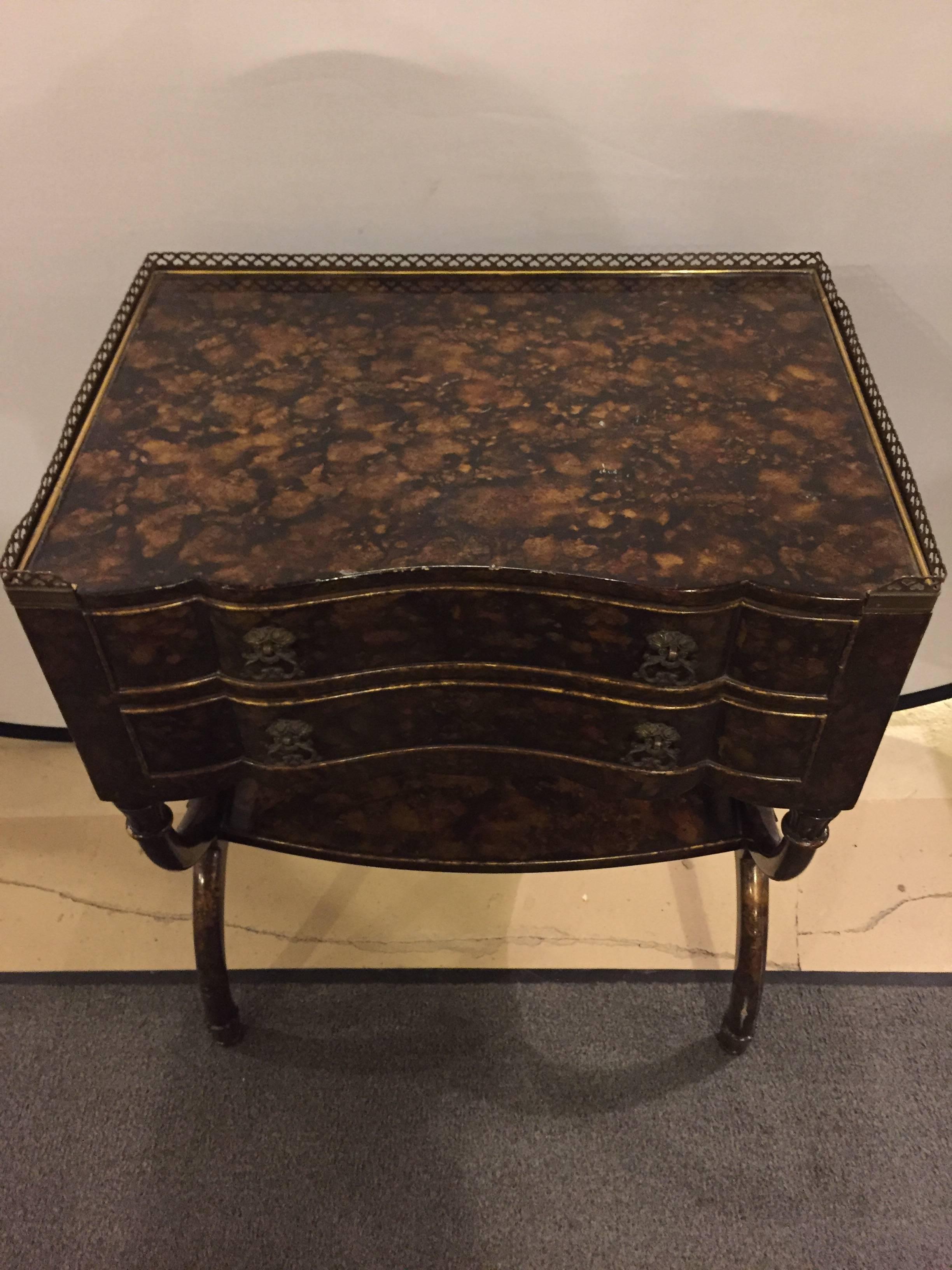 An Art Deco Regency style Faux tortoise decorated end table. Having two drawers and a lower shelf on double U formed legs.