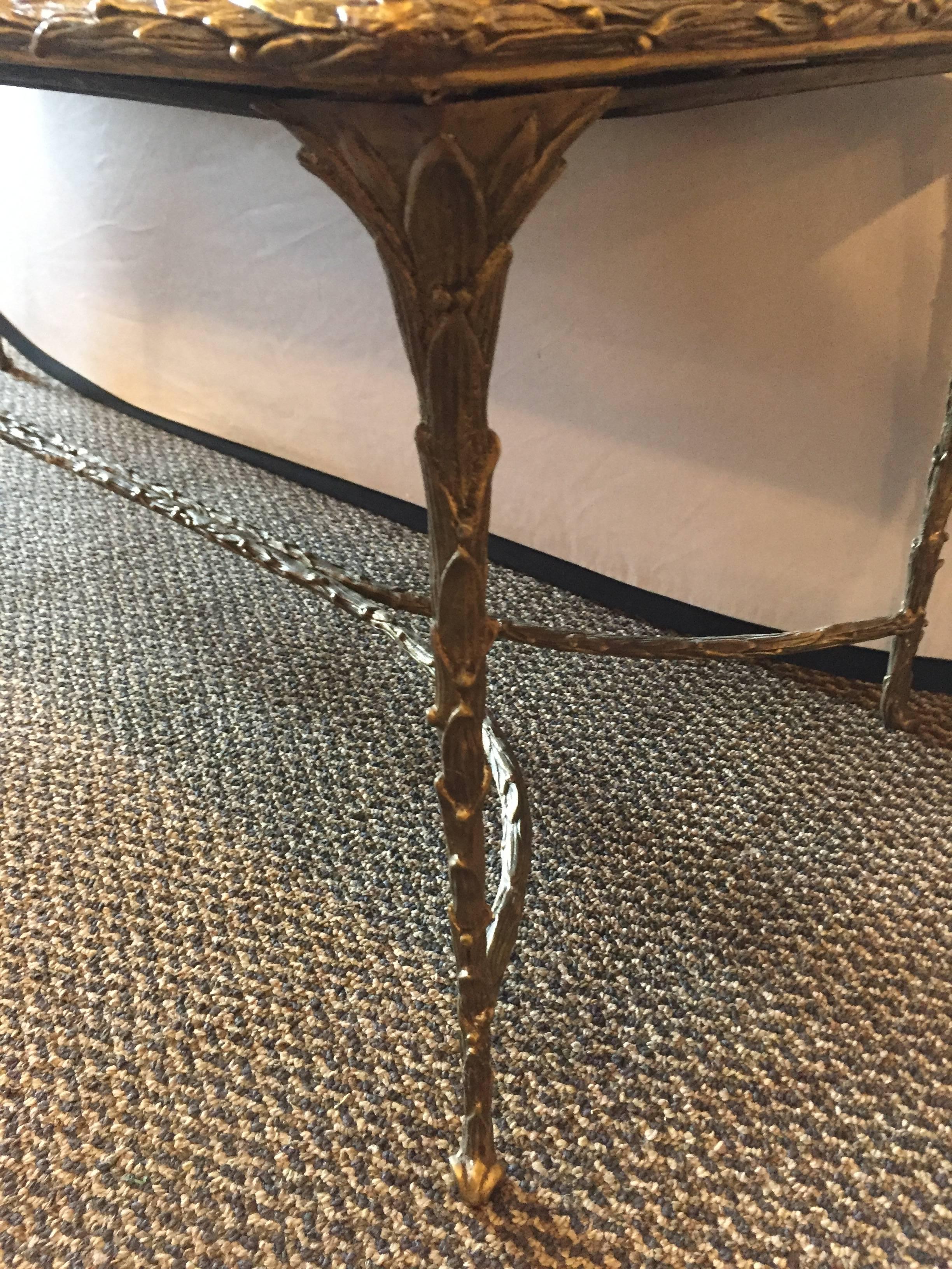 Maison Baguès gilt bronze coffee or cocktail low table. The fine and heavy leaf design gilt metal base indicative of this iconic designer style. This Hollywood Regency style coffee table sits on an X-form stretcher supporting an antiqued mirror