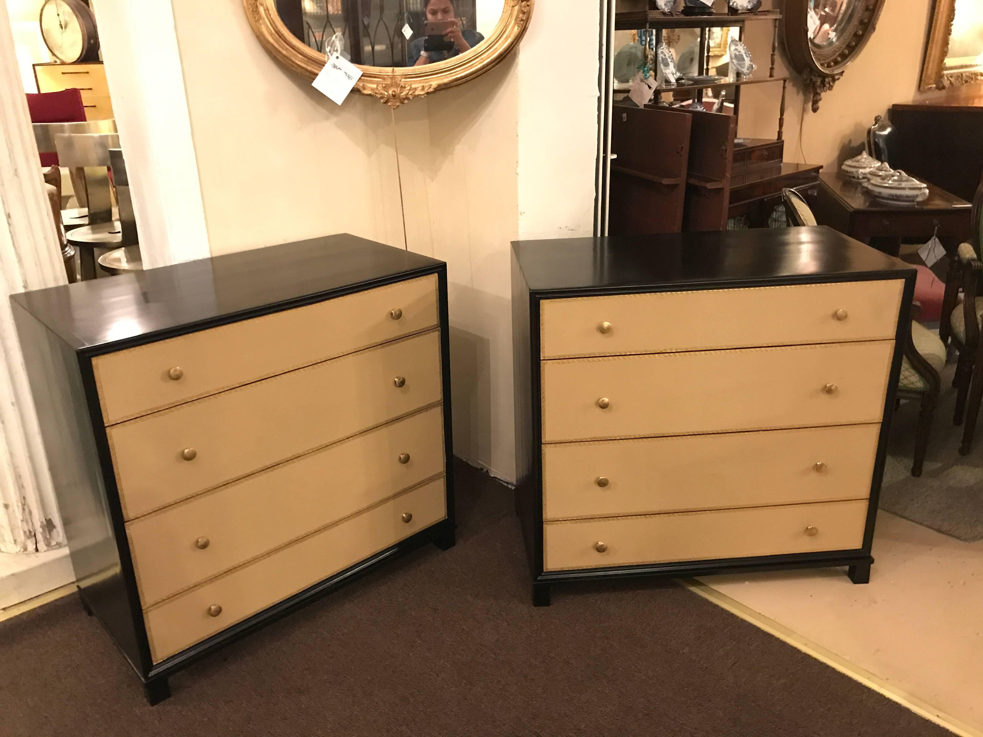A pair of Hollywood Regency style Tommi Parzinger fashioned four-drawer leather front with Greek key design chests. Each have a pair of large centre drawers with smaller drawers on the top and bottom in a tan leather with gilt gold Greek key design.