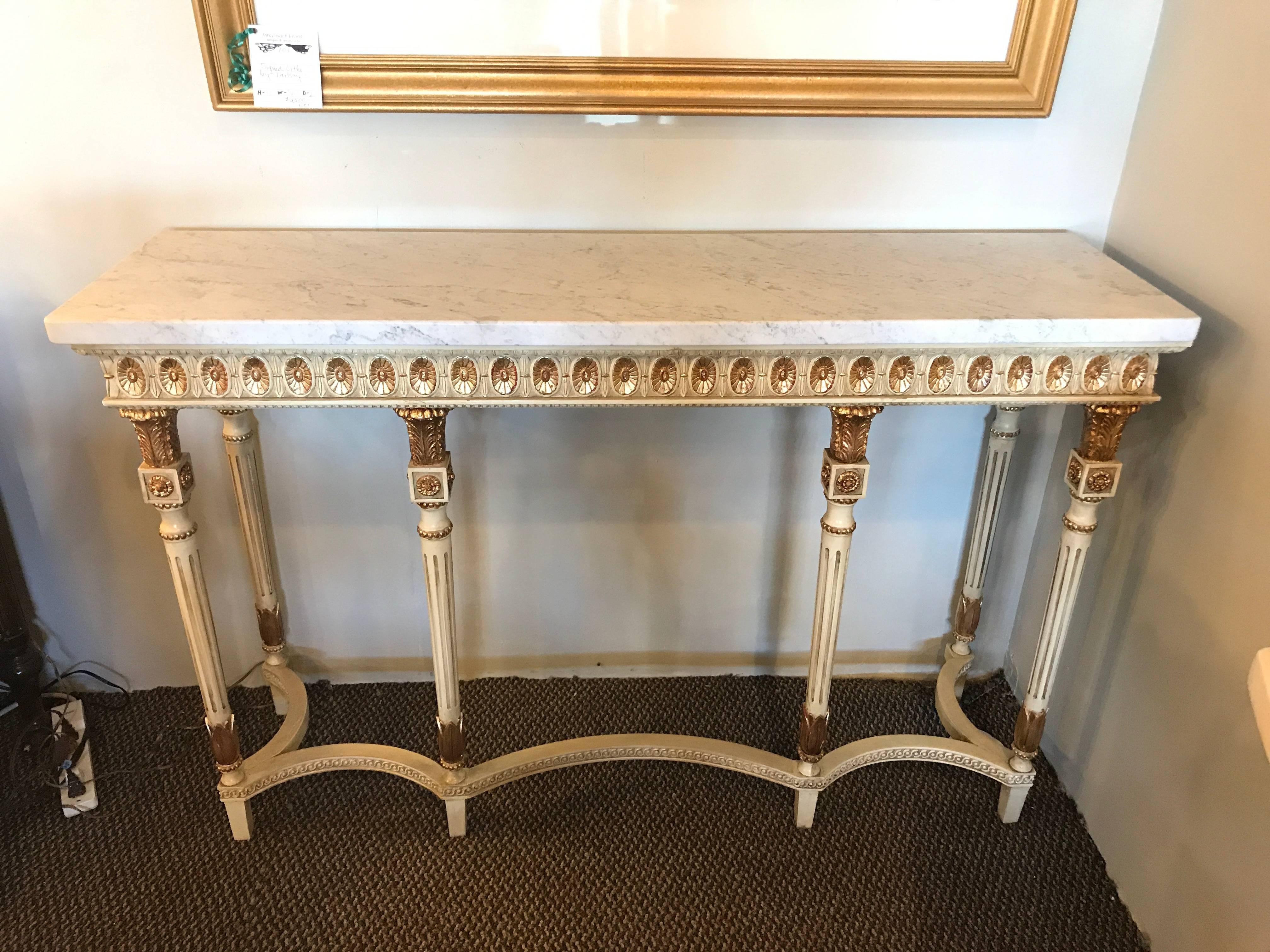 Pair of parcel-gilt and painted Louis XVI style consoles in the manner of Maison Jansen. Each having a fine Lancaster white color with gilt gold accents. The finely carved and tapering set of six legs supported by a curved undercarriage. The white