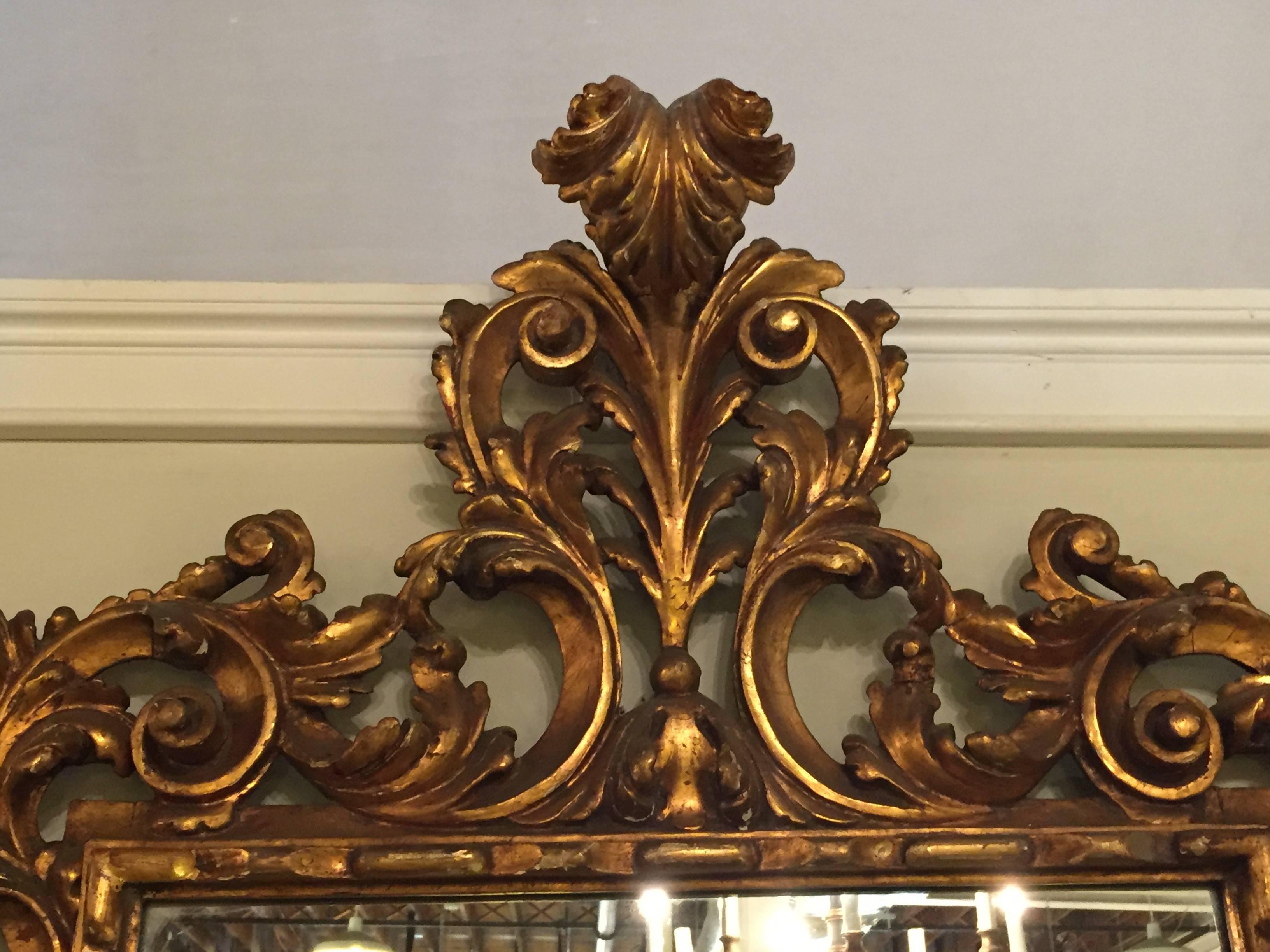 Pair of continental antique gesso and gilt gold carved wall or console mirrors. Each having a wonderfully detailed carved frame of the Rococo taste. Great for a pair of consoles or as bathroom mirrors.