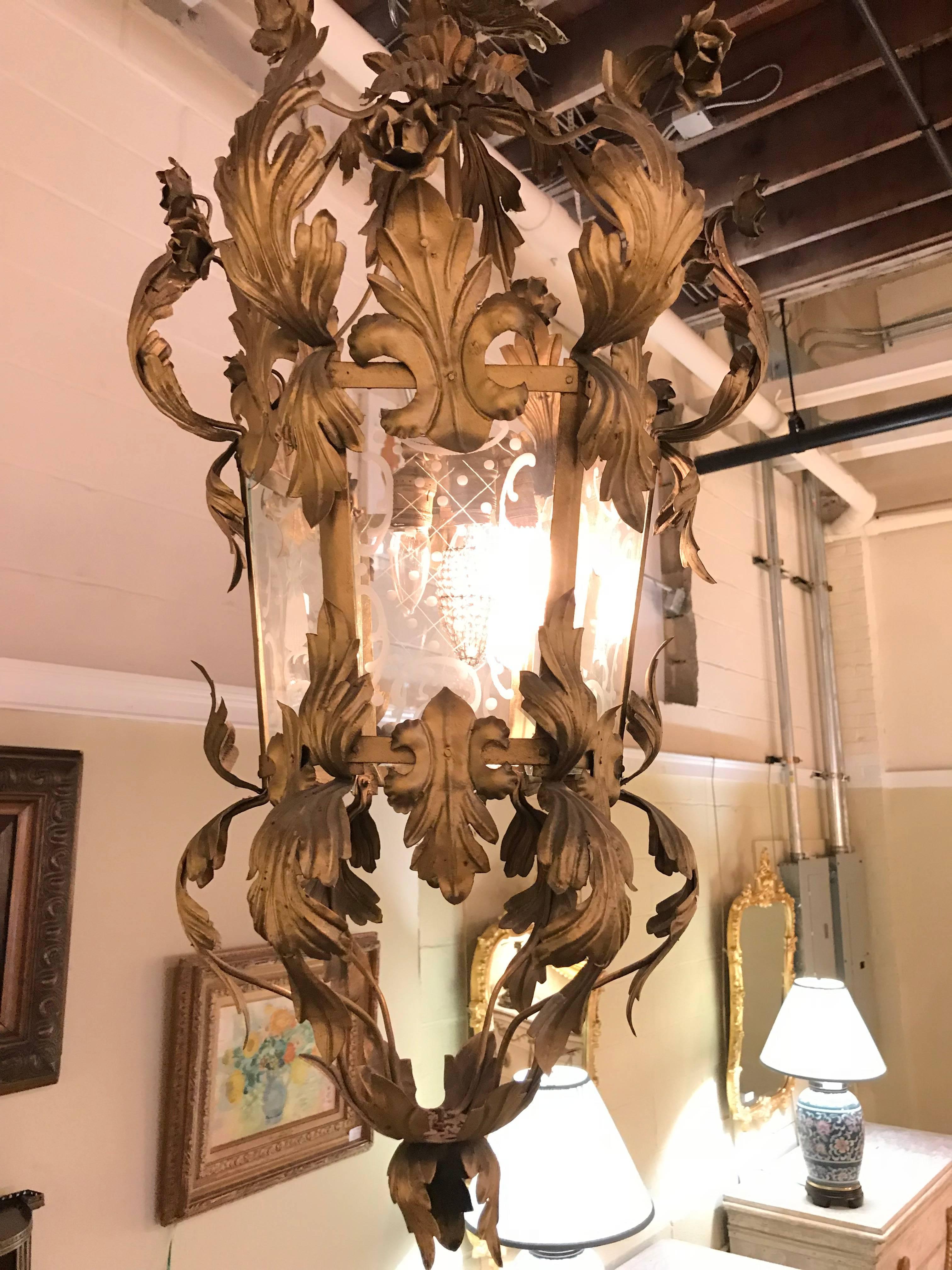 Gilt metal etched glass hanging lantern. This Mid-Century Modern lantern is finely decorated with a gilt metal scroll and vine design having etched glass panels.