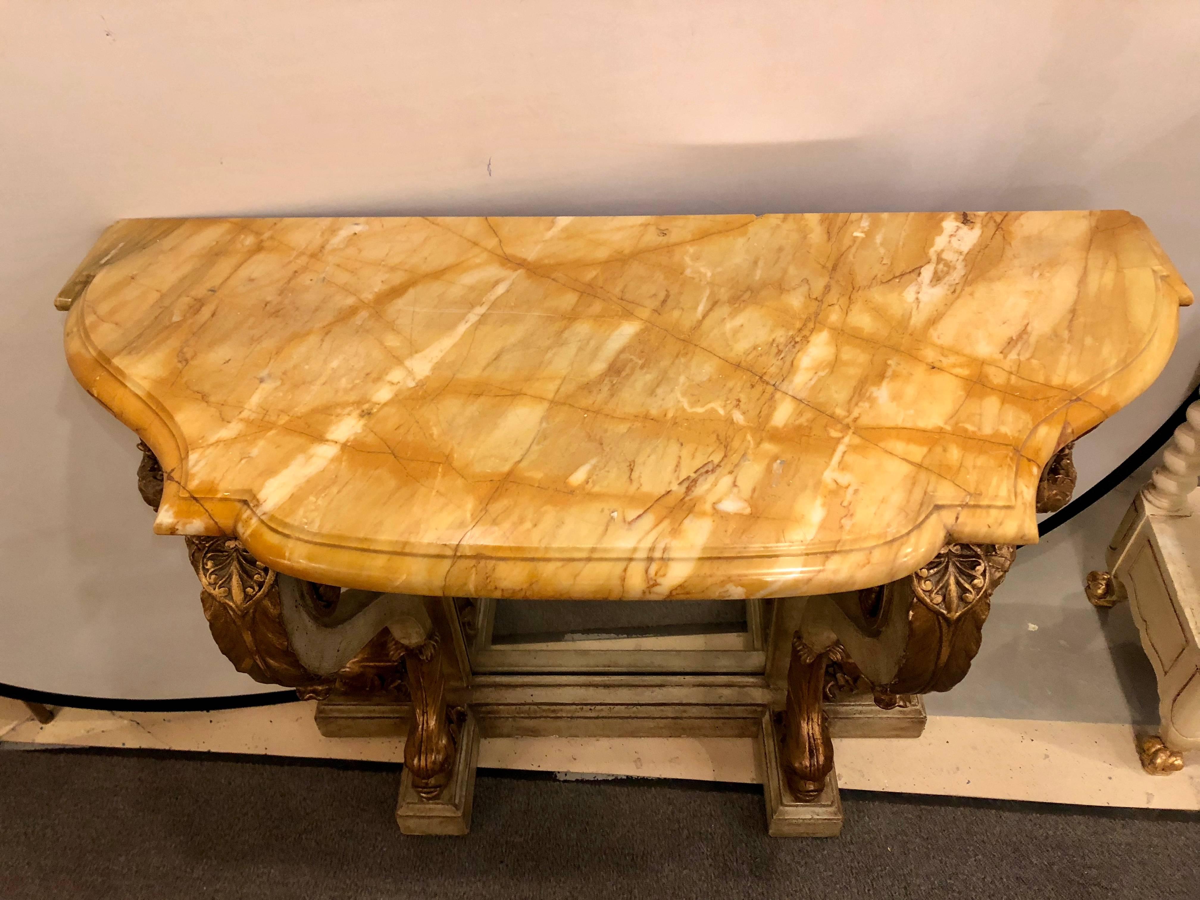 Late 19th century, Continental, the shaped and bowed marble top with a molded edge, and raised on a mirrored back and scrolling acanthine-carved supports joined by gilt foliate garlands and ending in dolphin supports, on a plinth base.