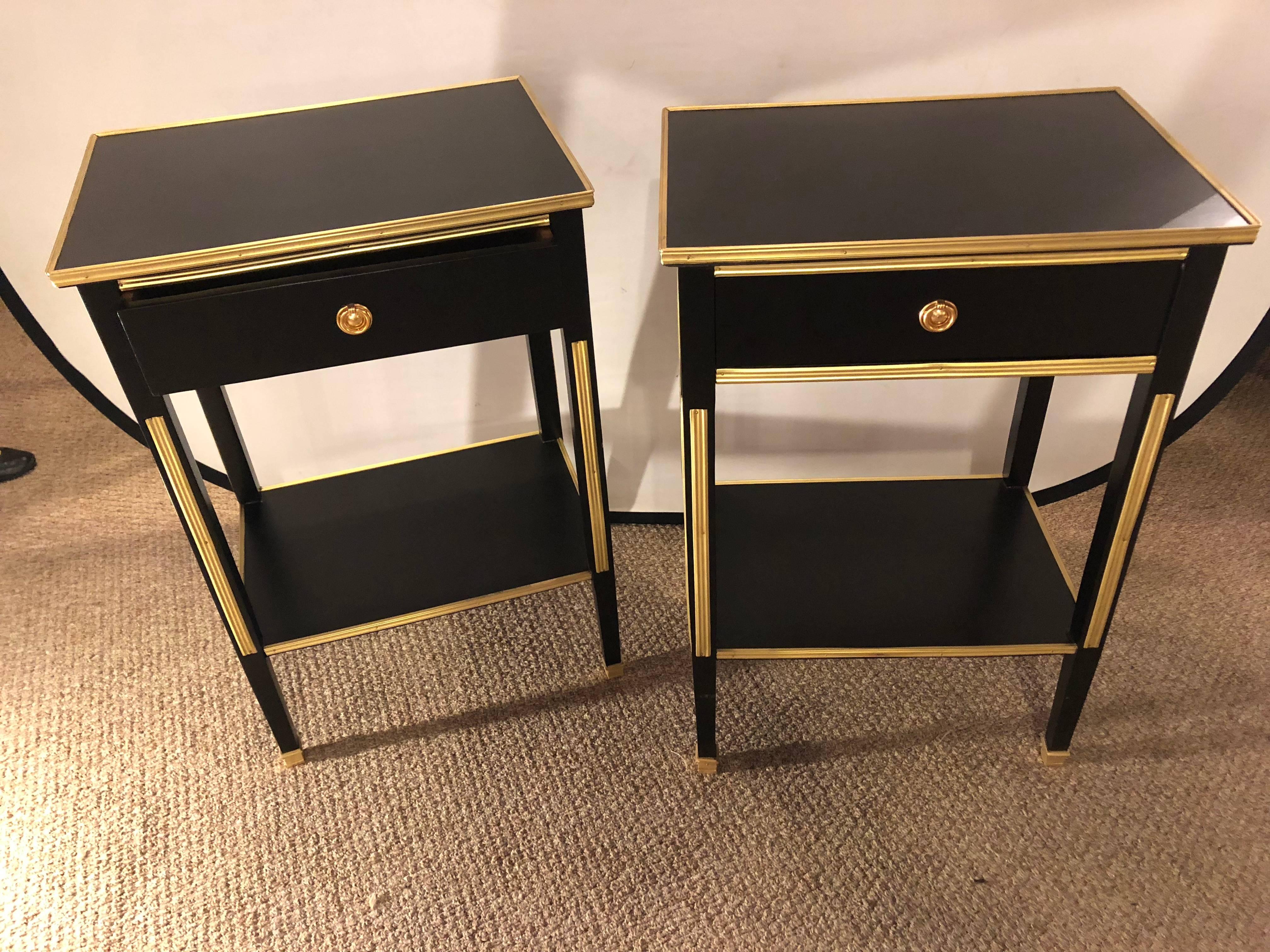 A pair of one drawer Russian neoclassical style stands or end tables. These sleek and stylish one drawer Hollywood Regency style bedside stands or end tables are simply as sweet as anyone could ask for. The case has been nicely polished in an ebony