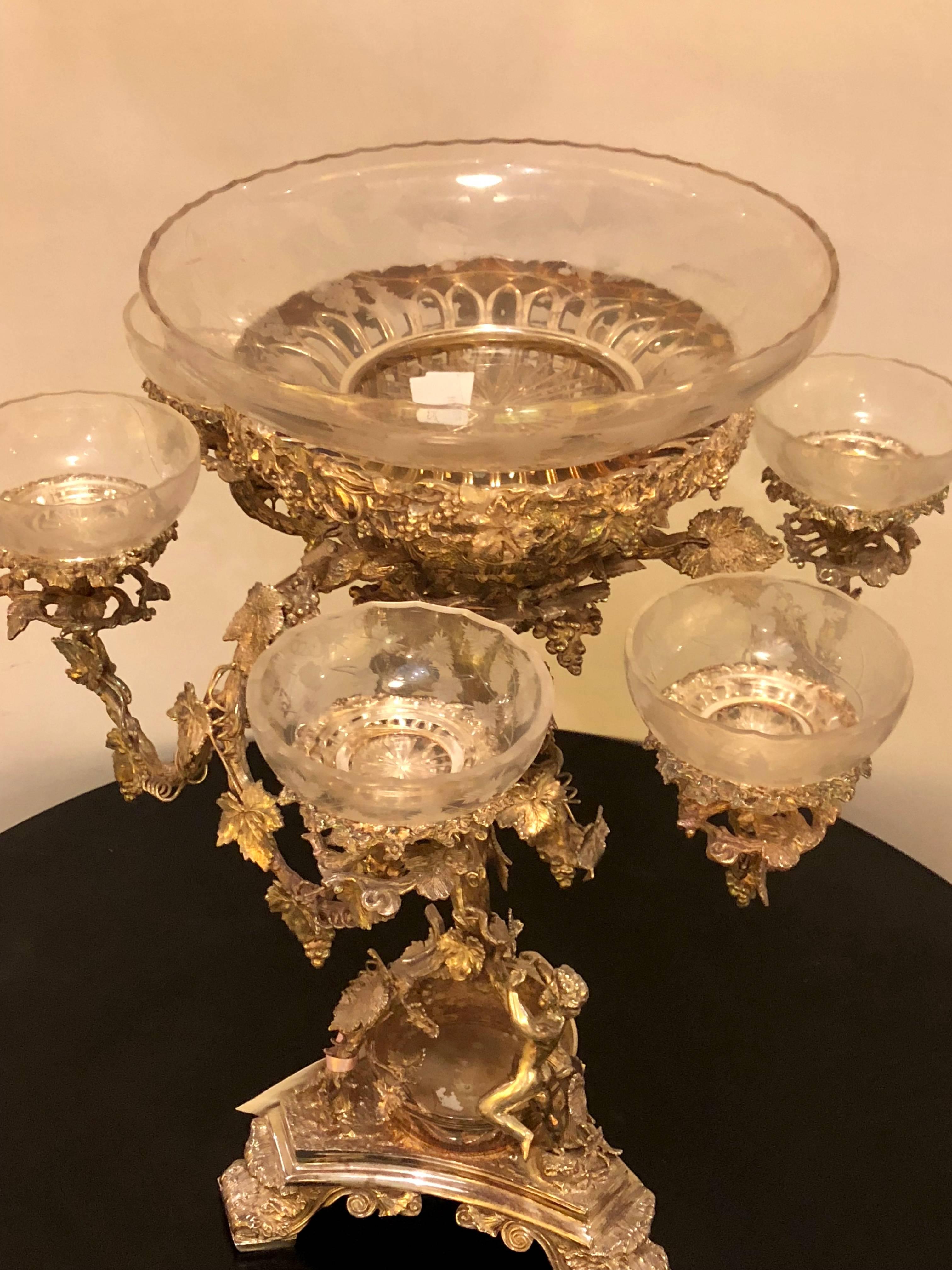 A silver plated finely cast centrepiece epergne with glass inserts. Of recent manufacture. Sure to add style and grace to any dining setting.