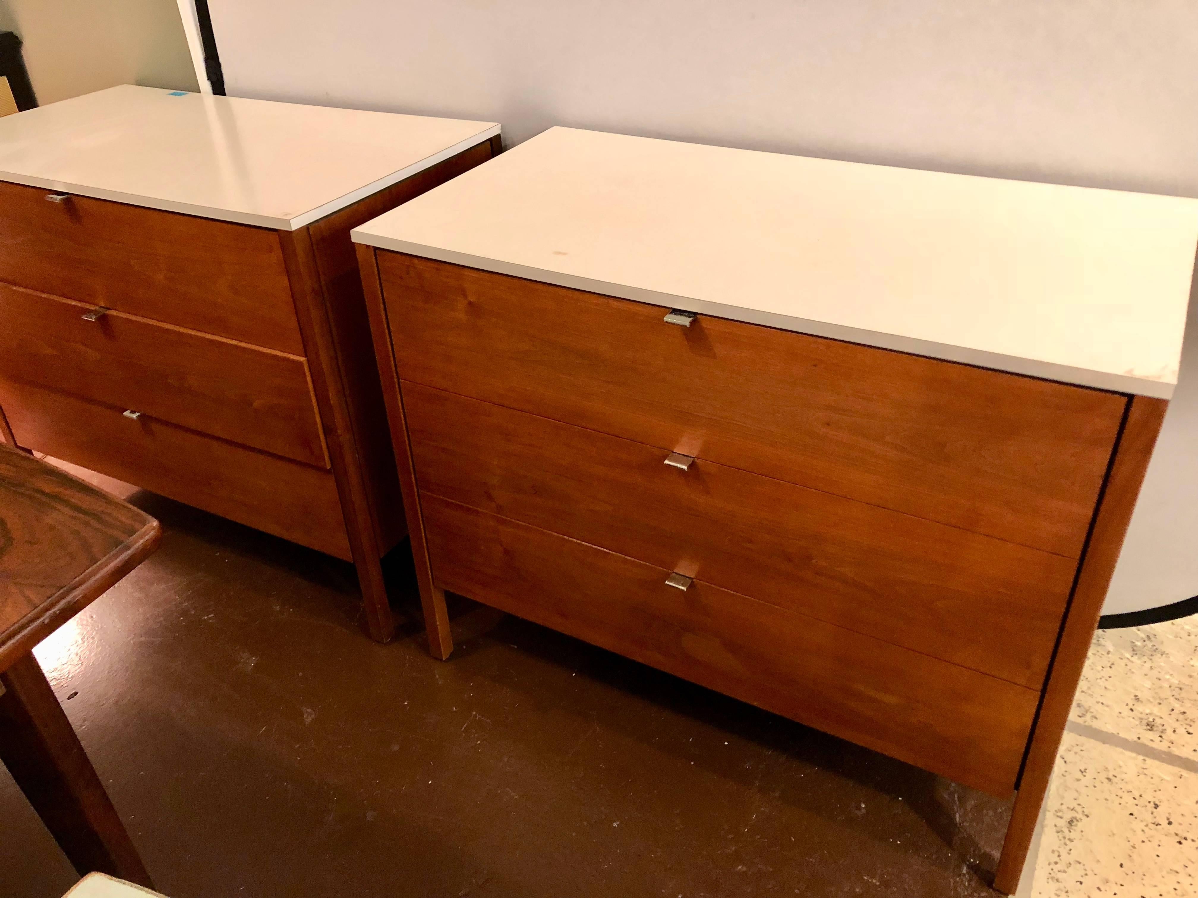 A pair of signed custom Florence Knoll and Associates Mid-Century Modern chests, commodes or nightstands. Laminate and chrome design with three graduating drawers all having chrome pulls supporting a white laminate top. The back fully finish in a