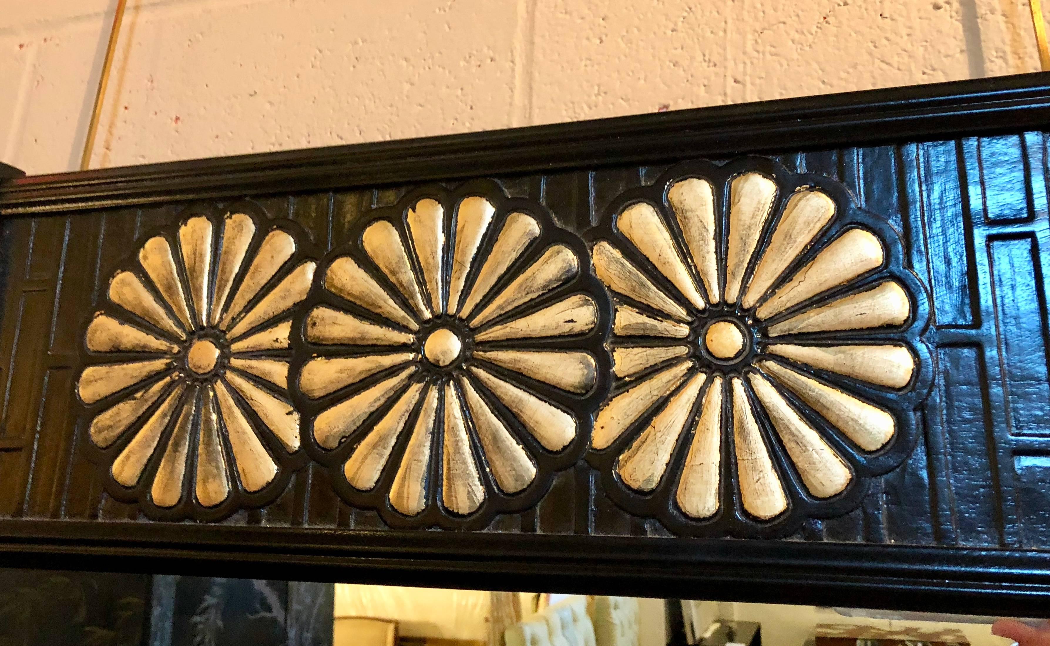 Pair of Hollywood Regency style American modern Regency style mirrors by John Widdcomb. Decorative gilt flowers on ebonized bamboo pattern frame. The centre mirror sitting in an ebony frame with column-form sides and an upper apron of brick