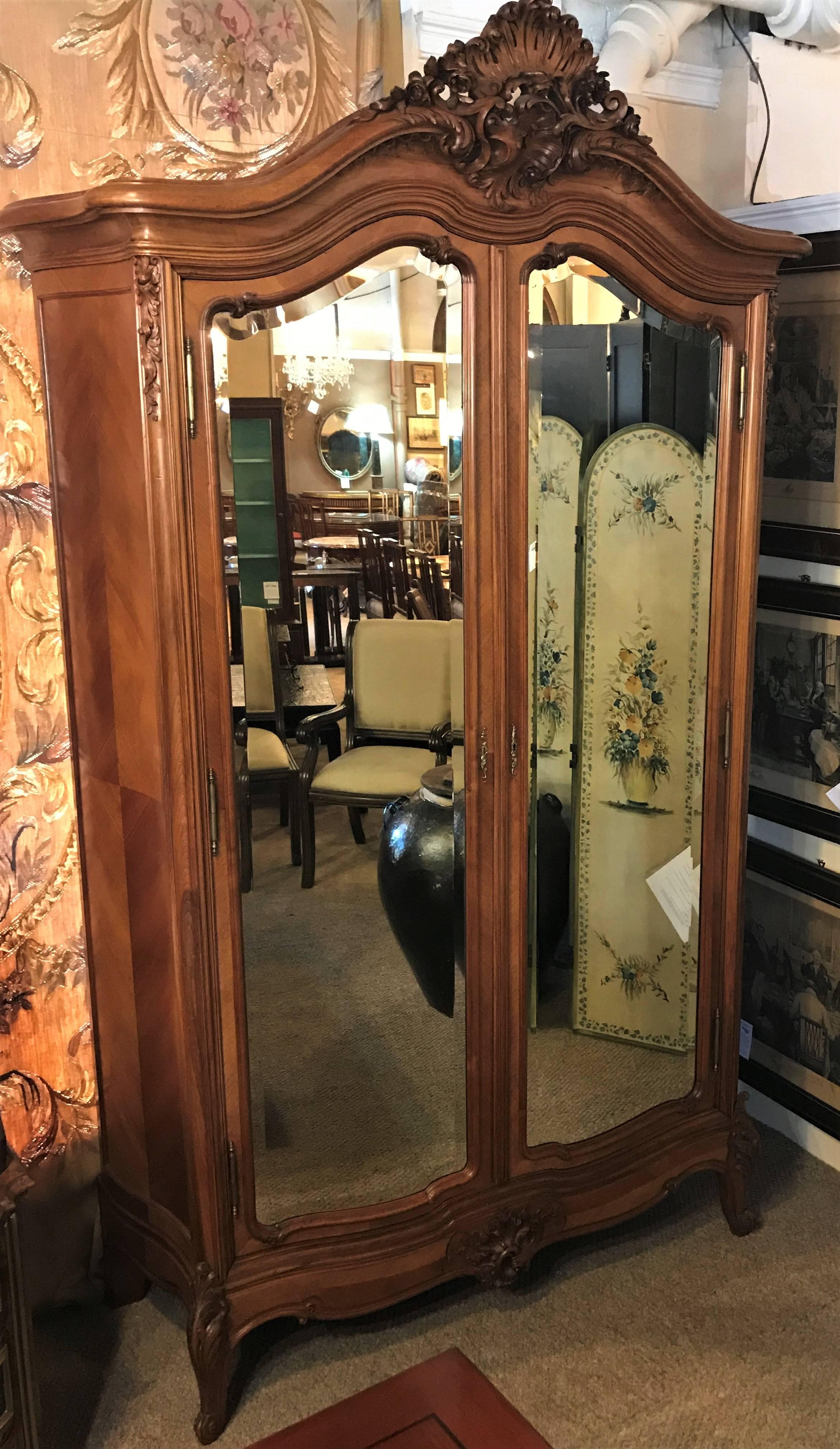 Louis XV style late 19th-20th century double door rosewood king sized armoire each single mirror door is 73 inches by 18 inches. Having three lower drawers and a shelved interior with custom fitted panels this is certainly one of the finest