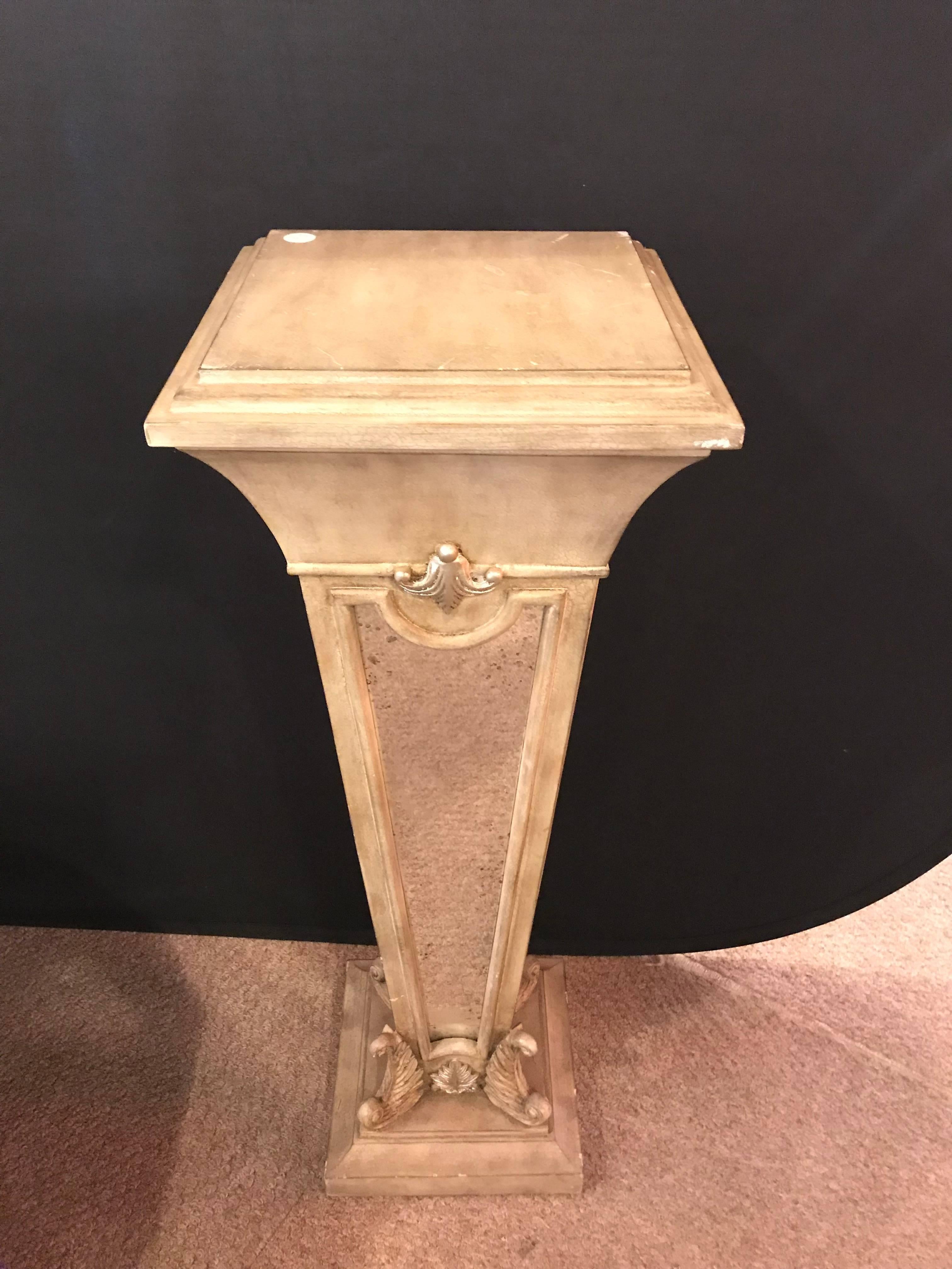 A Hollywood Regency style mirror and painted pedestal. This pedestal in square form with very nice carvings and mirrored side panels is a sure fire addition to any Art Deco or Hollywood Regency design setting.
