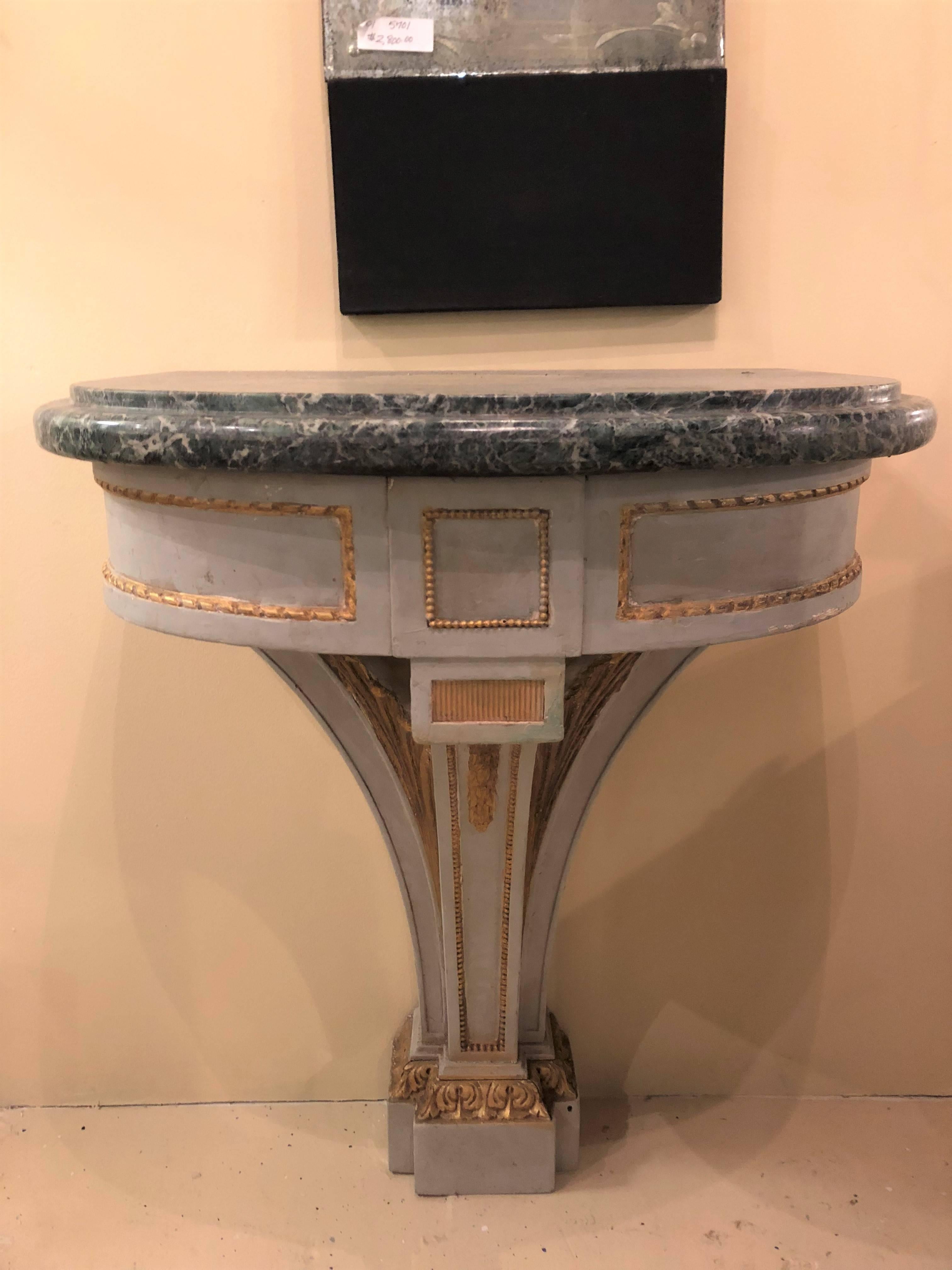 Pair of Hollywood Regency painted and marble demilune consoles. Each having a demilune form supporting a marble top. Parcel-gilt and paint decorated in the Maison Jansen form.
