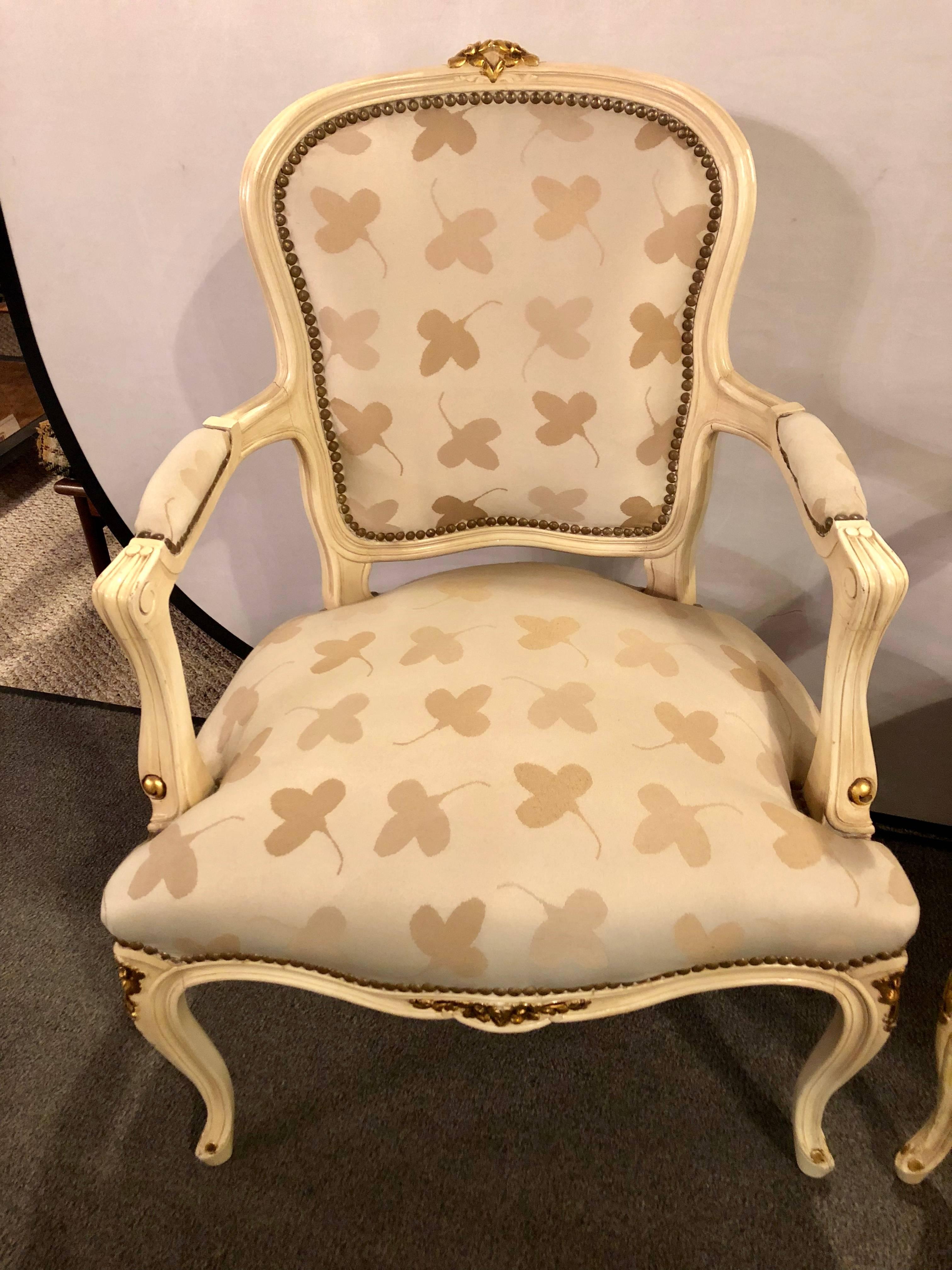 Pair of French Louis XV style parcel-gilt and paint decorated bergere chairs Jansen inspired. These lovely and elegant armchairs would look spectacular in any living room or office setting. Both in a clean tweed style leaf design fabric with a seat