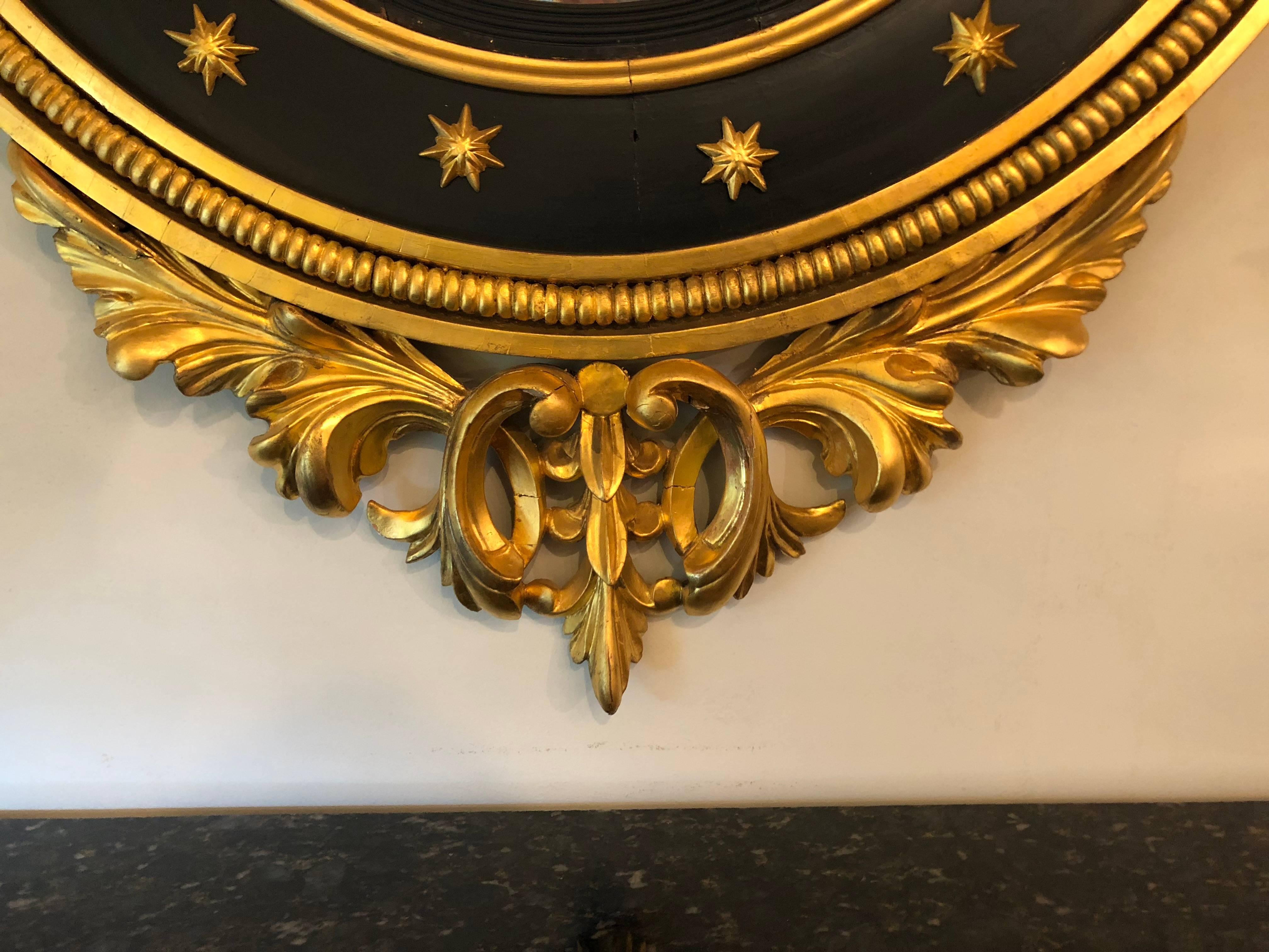 Regency-Spiegel aus dem späten 19. oder sehr frühen 20. Jahrhundert, geschnitzt und ebonisiert aus vergoldetem Holz. Der konvexe Spiegel ist in einen spektakulären, mit Ebenholz und Gold verzierten Rahmen eingefasst, dessen unterer Teil zu einem