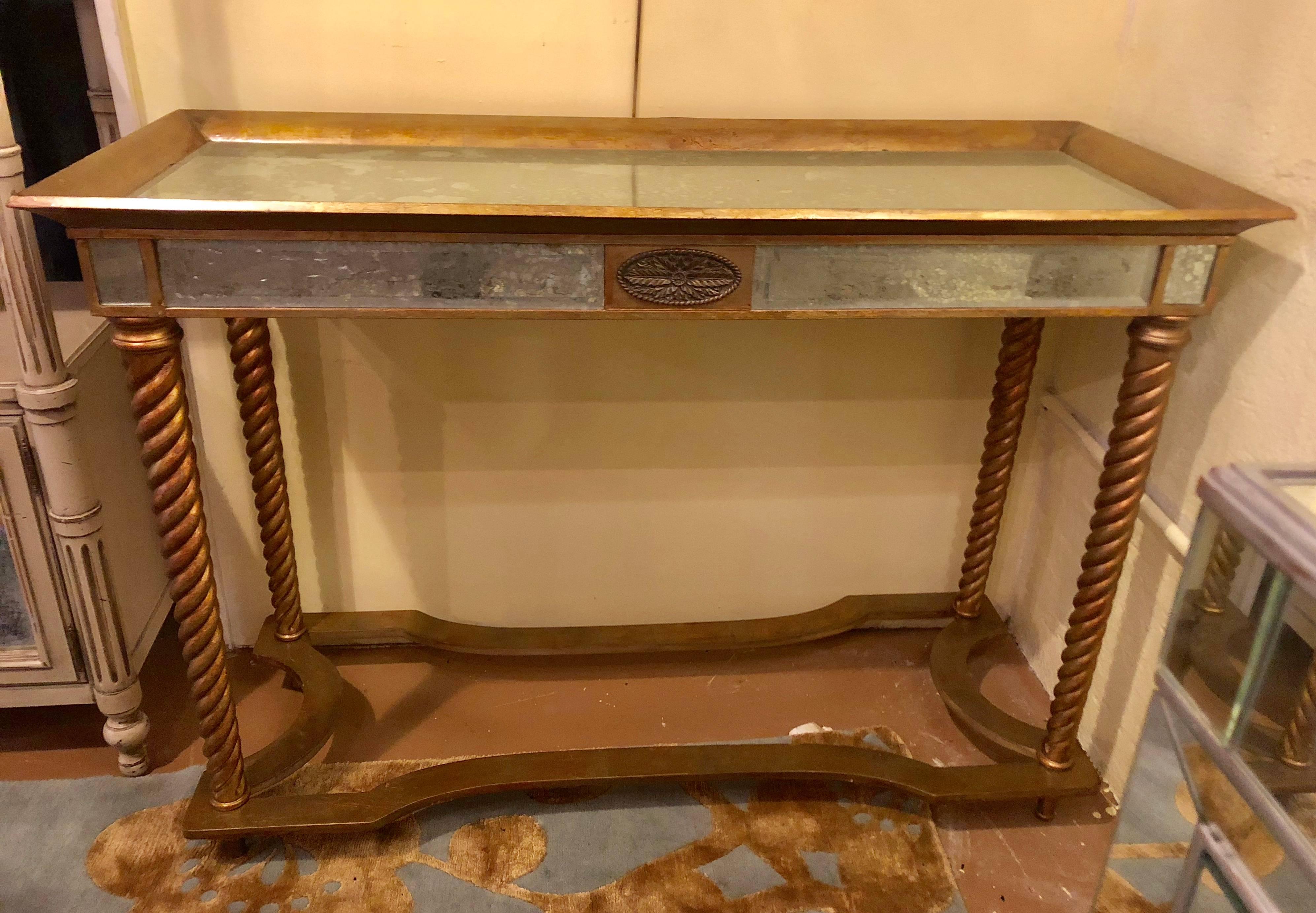 A mirrored console or sofa table with giltwood barley twist legs. From the Hollywood Regency Era comes this finely designed and detailed console or sofa table. The wood frame with mirrored top, apron and design.