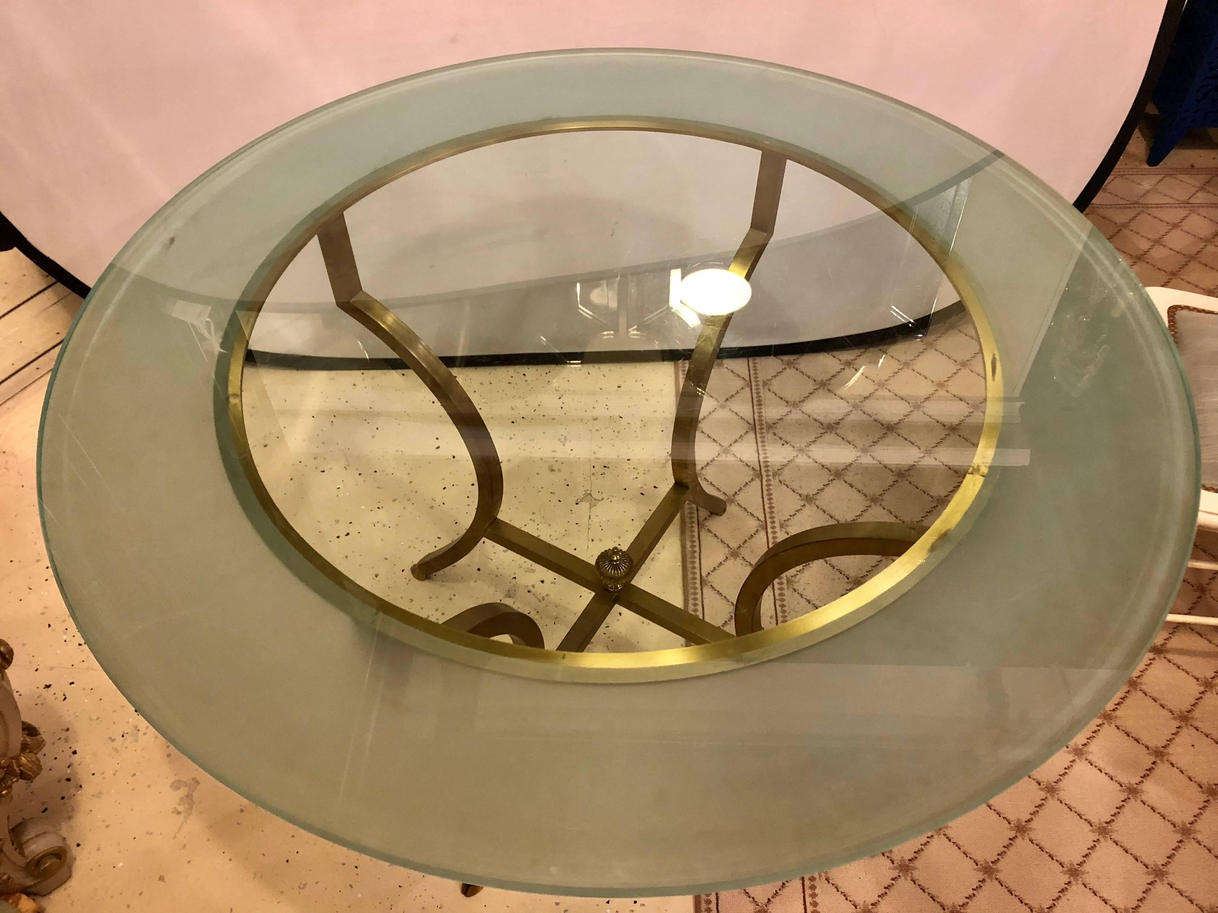 Maison Jansen inspired Hollywood Regency style glass top bronze based center table or dining table. This oddly shaped base of bronze form supports a circular glass top and can be used as a dining table or a centre table. The finely cast hoof feet