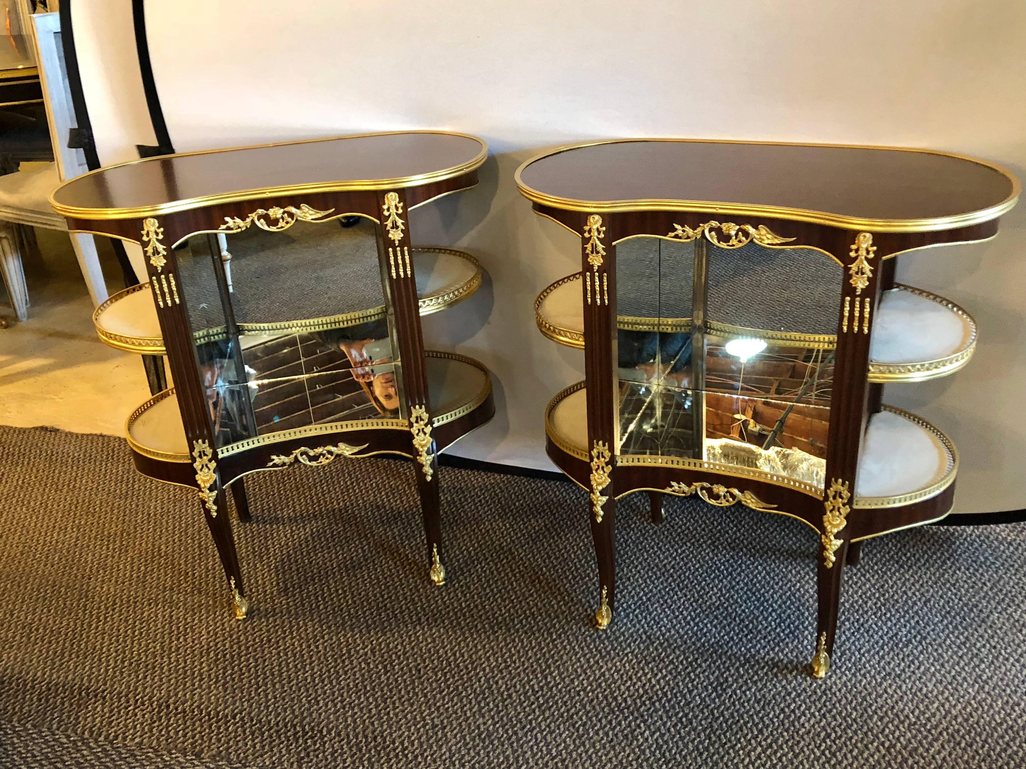 A very fine and decorative pair of Louis XV Hollywood Recency style crotch mahogany vitrine form end tables or nightstands. These custom quality nightstands can be used as end tables or showcase pieces in a vestibule. The bronze mounts are
