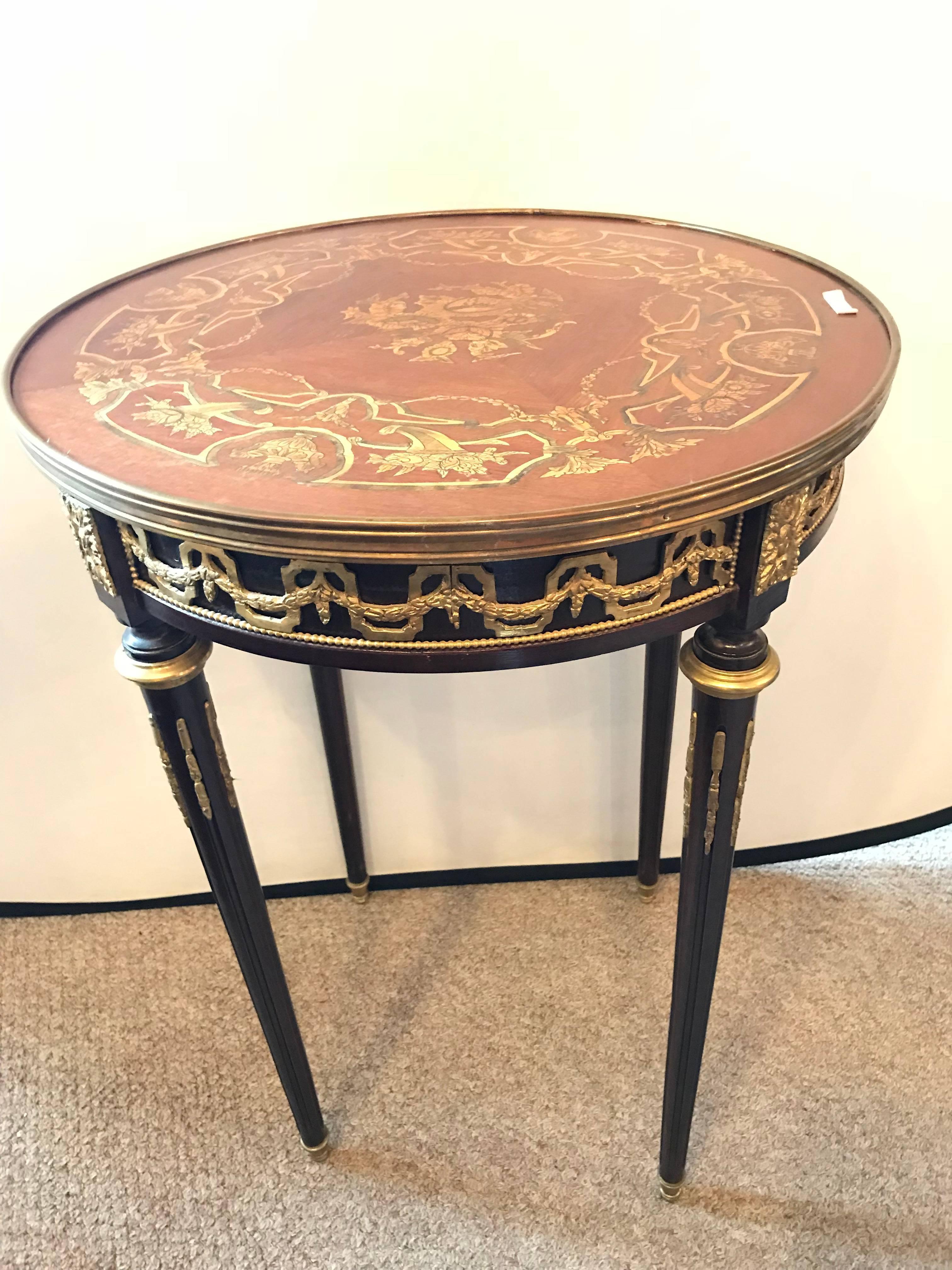 A Maison Jansen style French inlaid Bouillotte end or lamp table. Bronze mounts abound on this fine Louis XVI style end table. The reeded tapering legs with bronze mounts leading to support a bronze banded inlaid top.