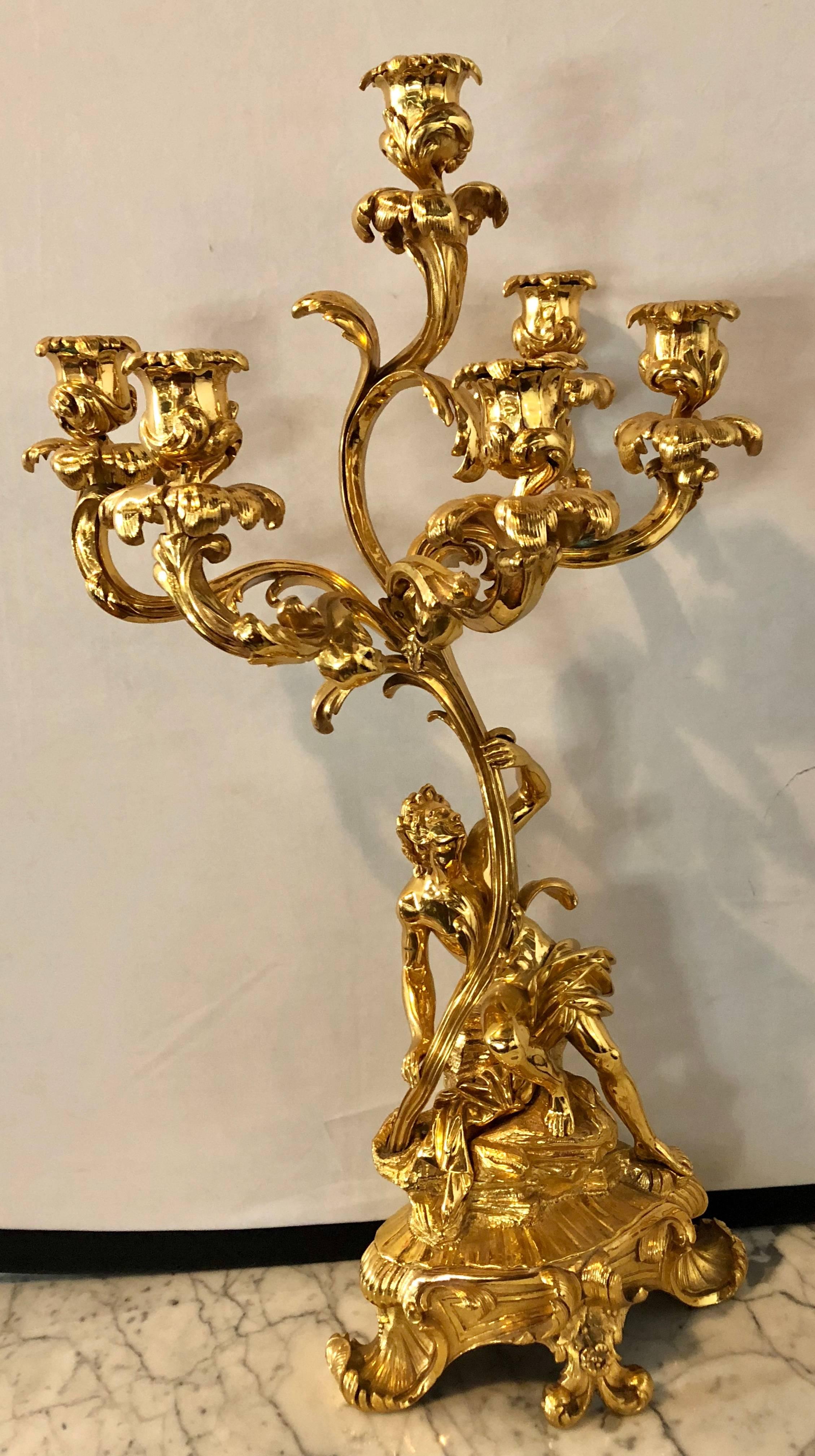 Pair of stunning Louis XVI style 19th century bronze 24-carat gold-plated six-arm figural candelabras. Each having five arms forming a large candelabra supported by a man and the mate a woman each standing full figured on a pedestal base facing each