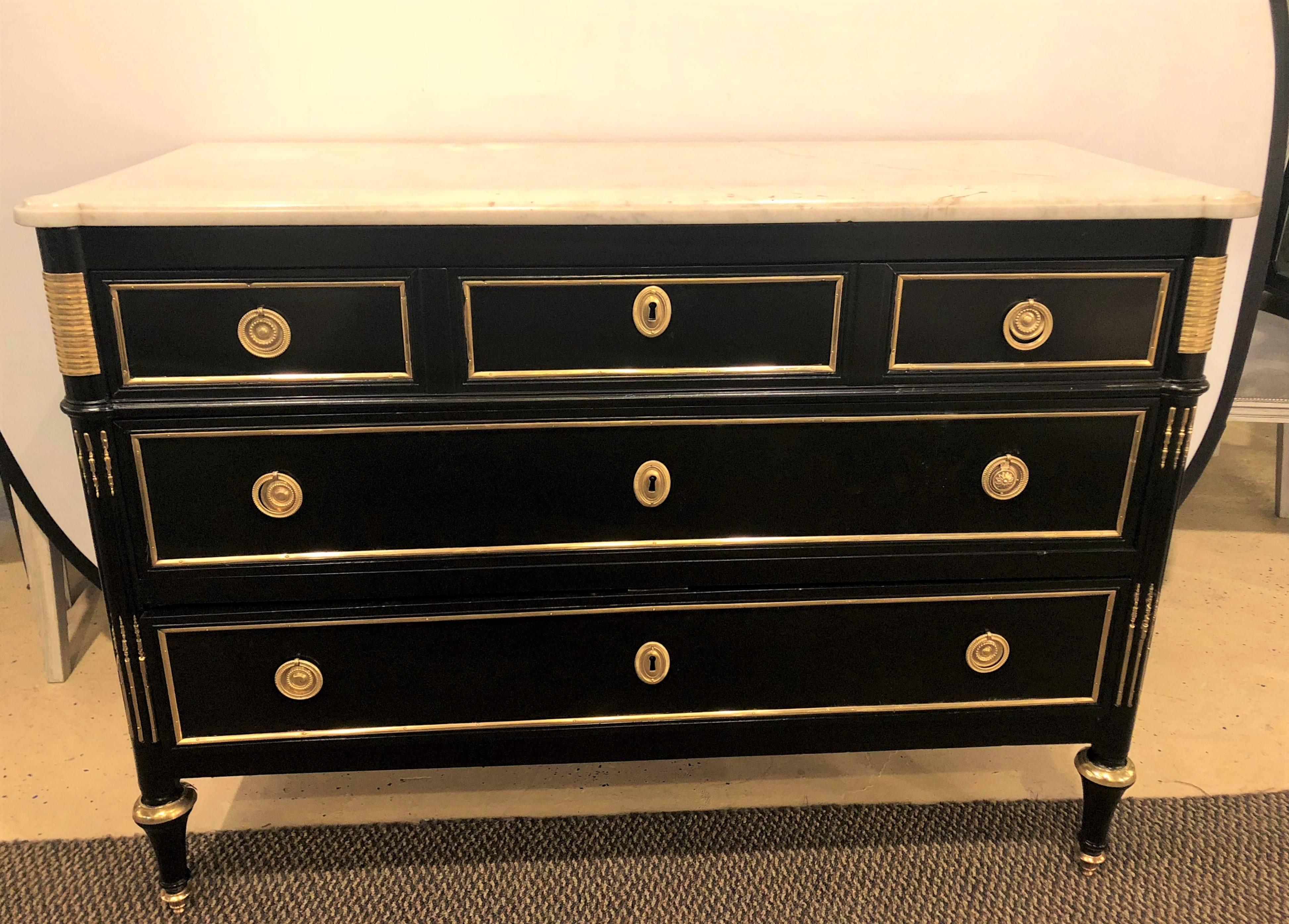 A Louis XVI style Hollywood Regency marble-top commode by Maison Jansen. This commodes depicts this iconic designers flair for style and grace at its peak. The oak lined secondary structure finished in an ebony and bronze-mounted fashion. The case