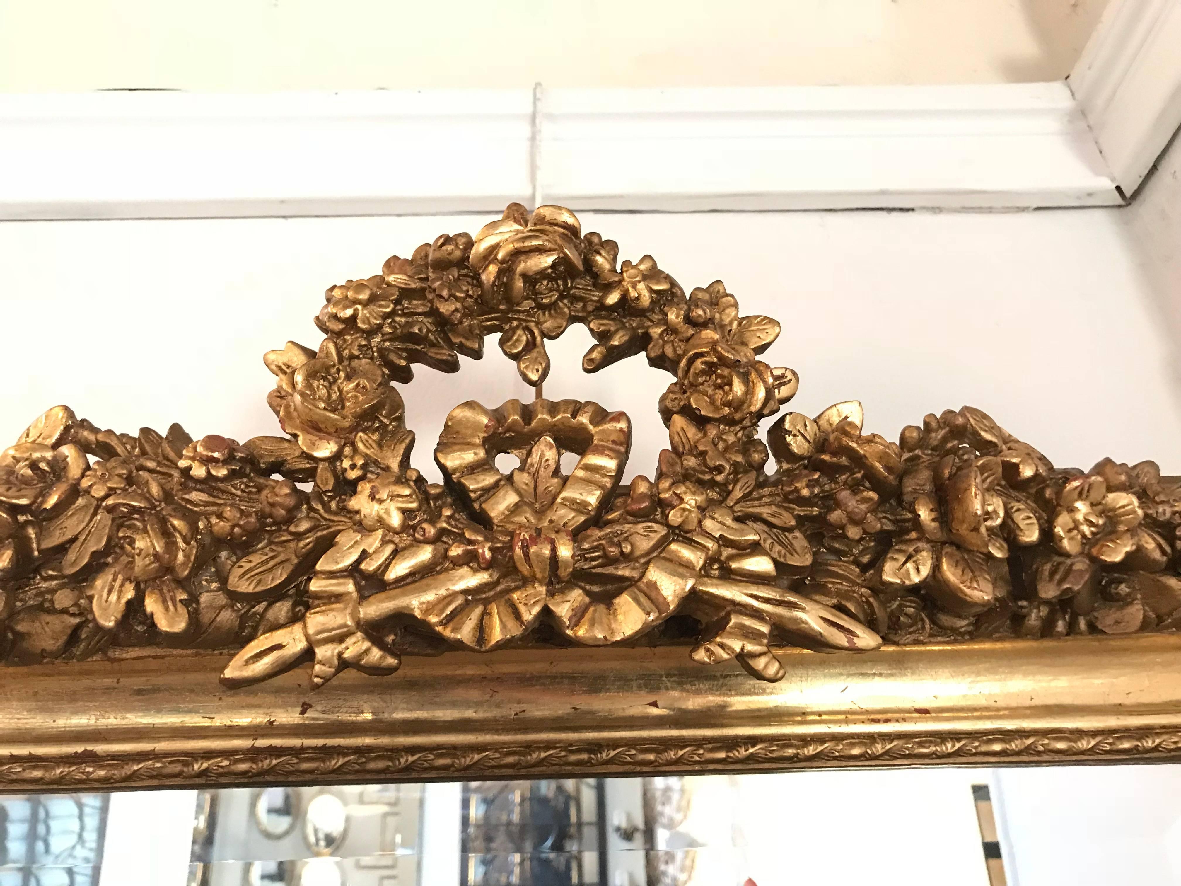 A Pair Of Louis XVI Style Gilt and Gesso Wood Ribbon Tassel Rose Carved Mirrors each having a one inch beveled mirror. The mirror itself sits in a rectangular from of fine gilt carved sides depicting groups of roses with leaf and vine design. The