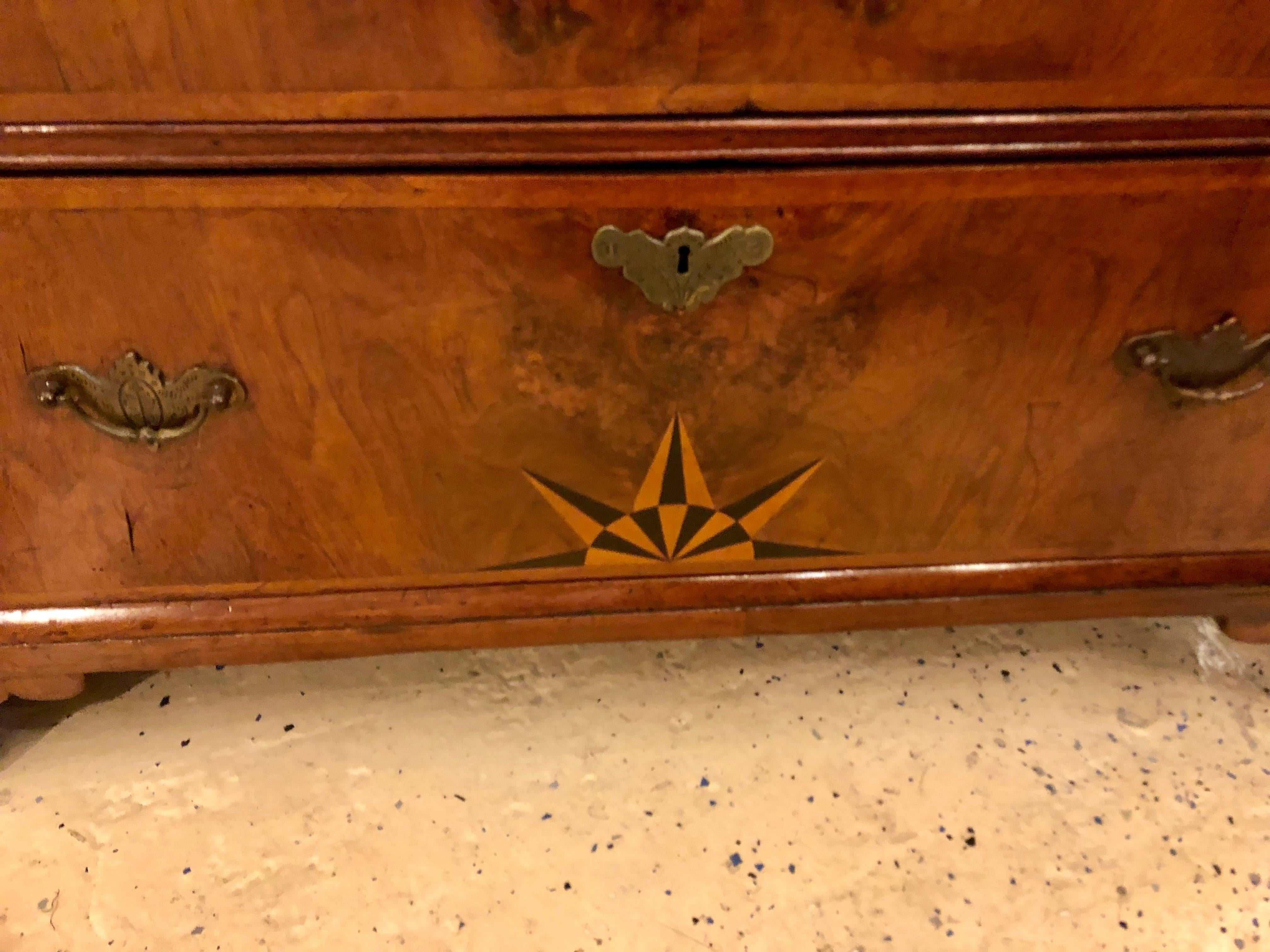 An 18 century German chest of drawers or commode. A fine German period commode with spectacular inlays on the top and lower drawer bearing a starburst design. Having its original bracket feet this is surely a prize for any true antique collector.