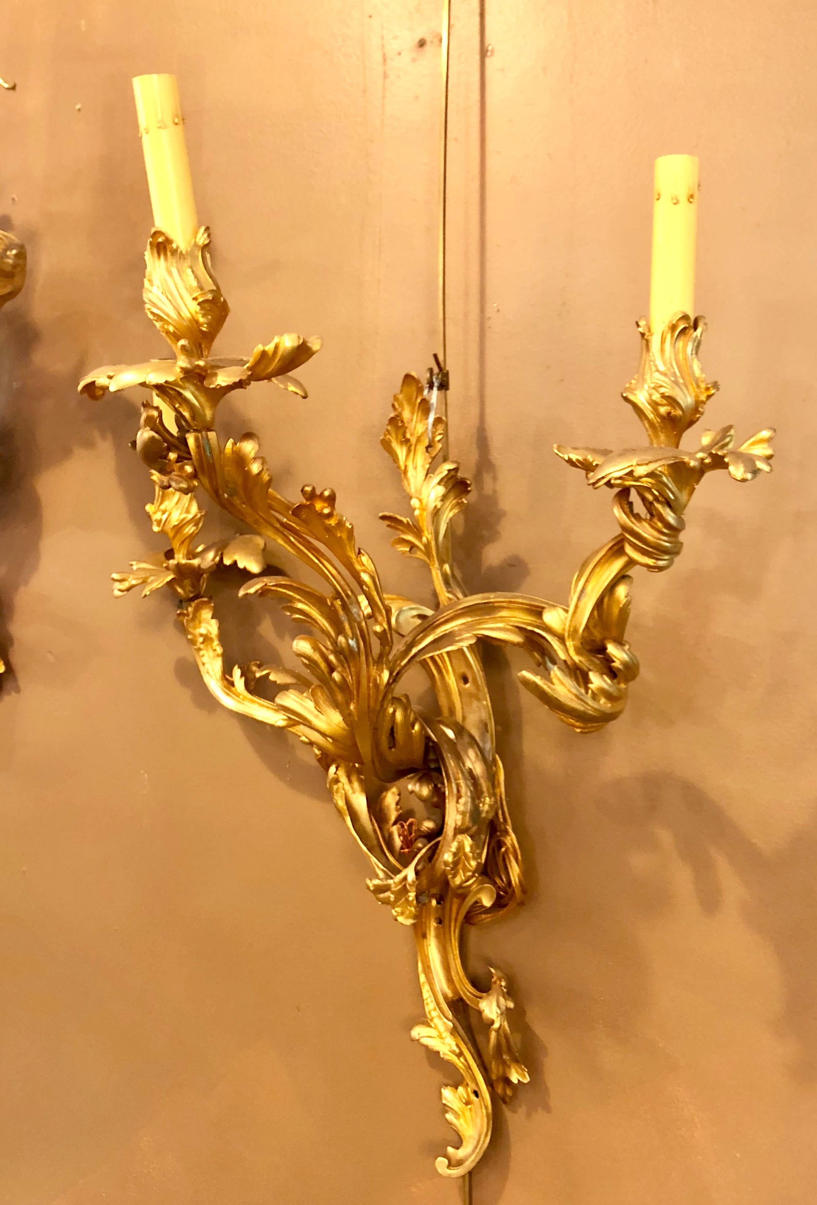 A pair of Louis XVI style bronze three light gilt bronze sconces.