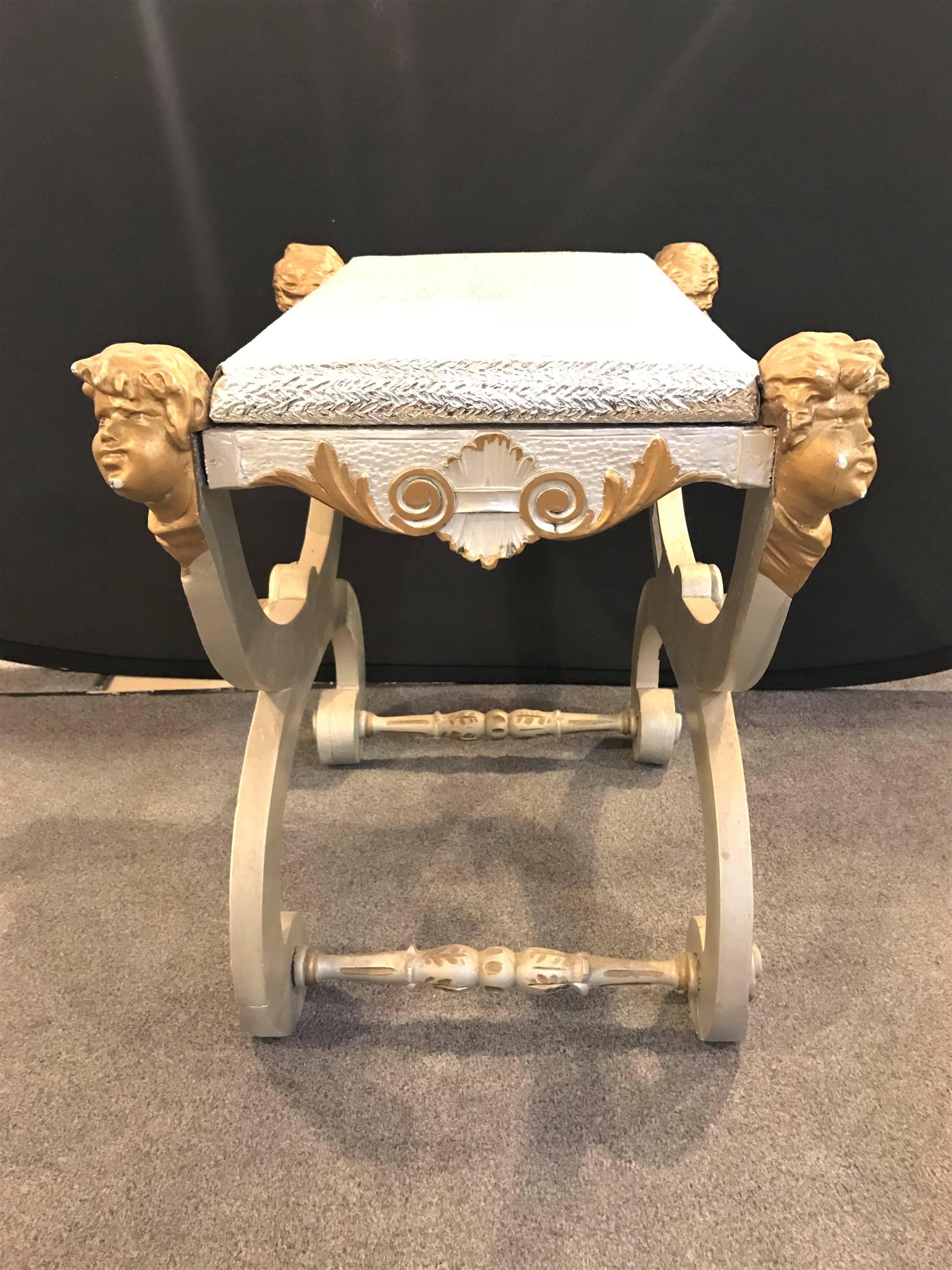 A fine antique Italian Cerule stool or bench with detailed cherub carvings in gilt.