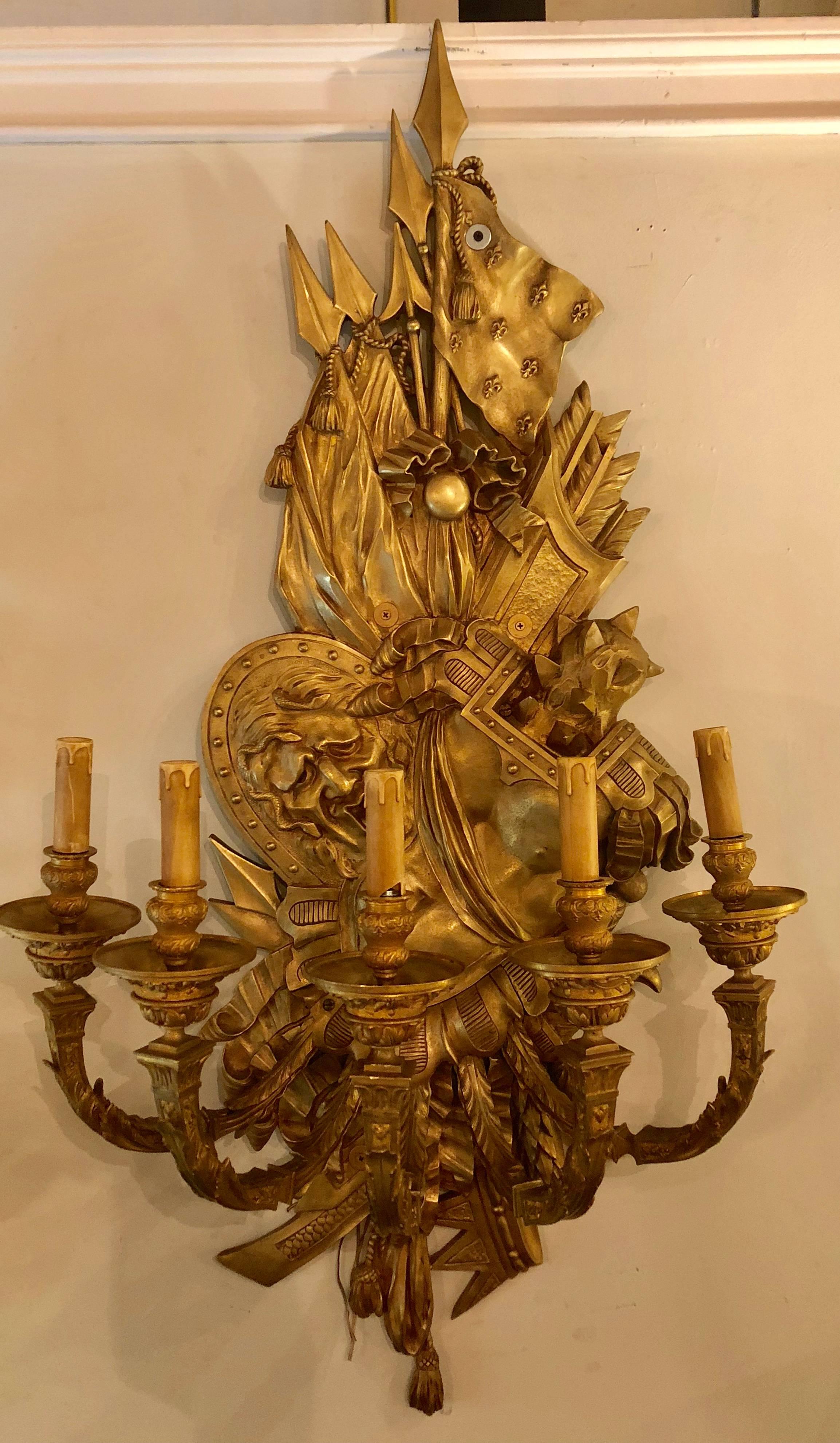 Pair of 19th century opposing bronze monumental five light wall sconces. Each of this enormous and palatial wall sconce have different opposing warriors in full suited amour. One with a man having snakes in his hair the other facing him is a lion.