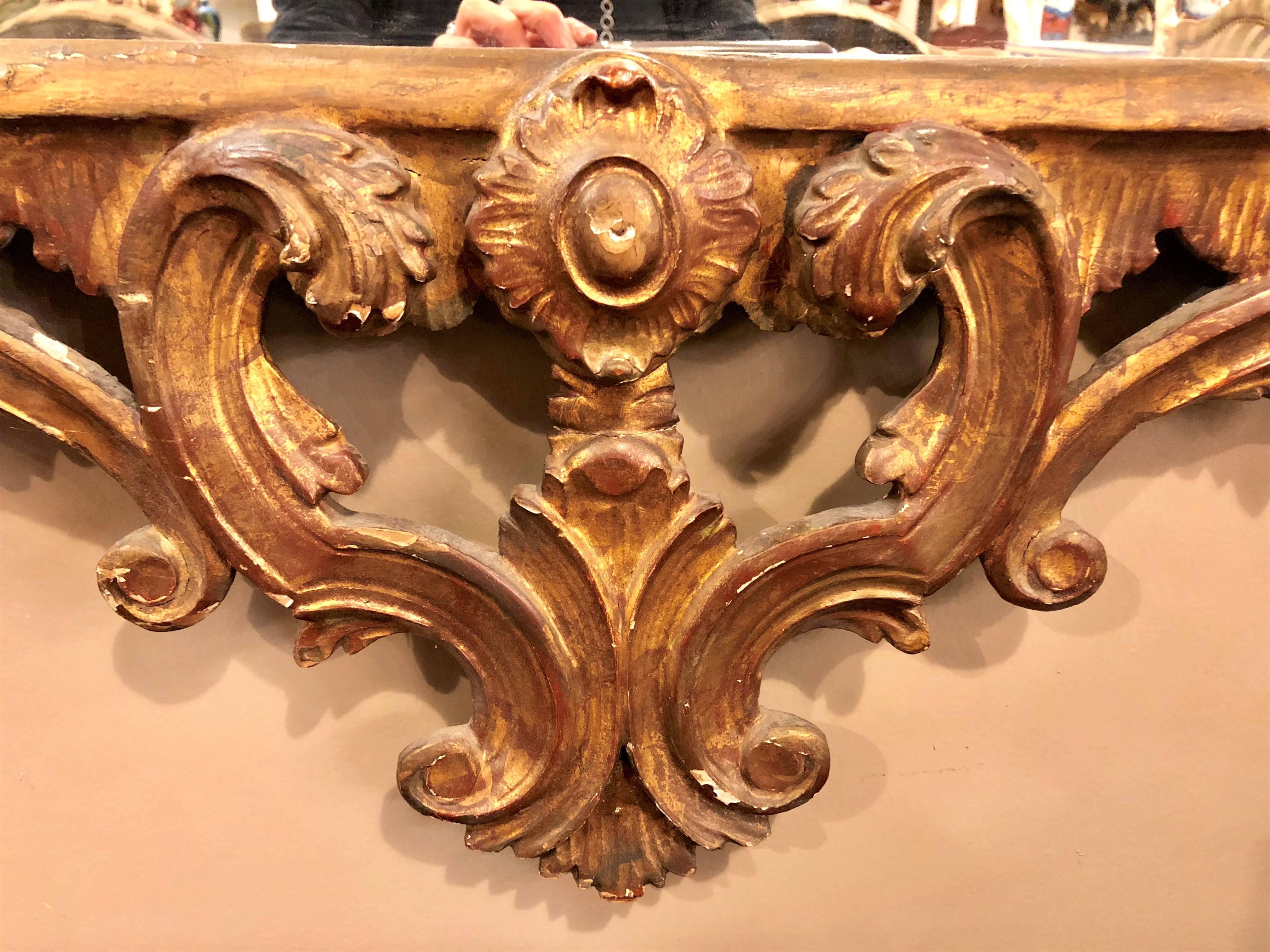 A Chinese Chippendale style giltwood and gesso wall or console mirror. Having a carved pagoda top with flowers, leafs and vine design this wonderfully decorative wall or console mirror is a fine depiction of the style and grace that adorned the