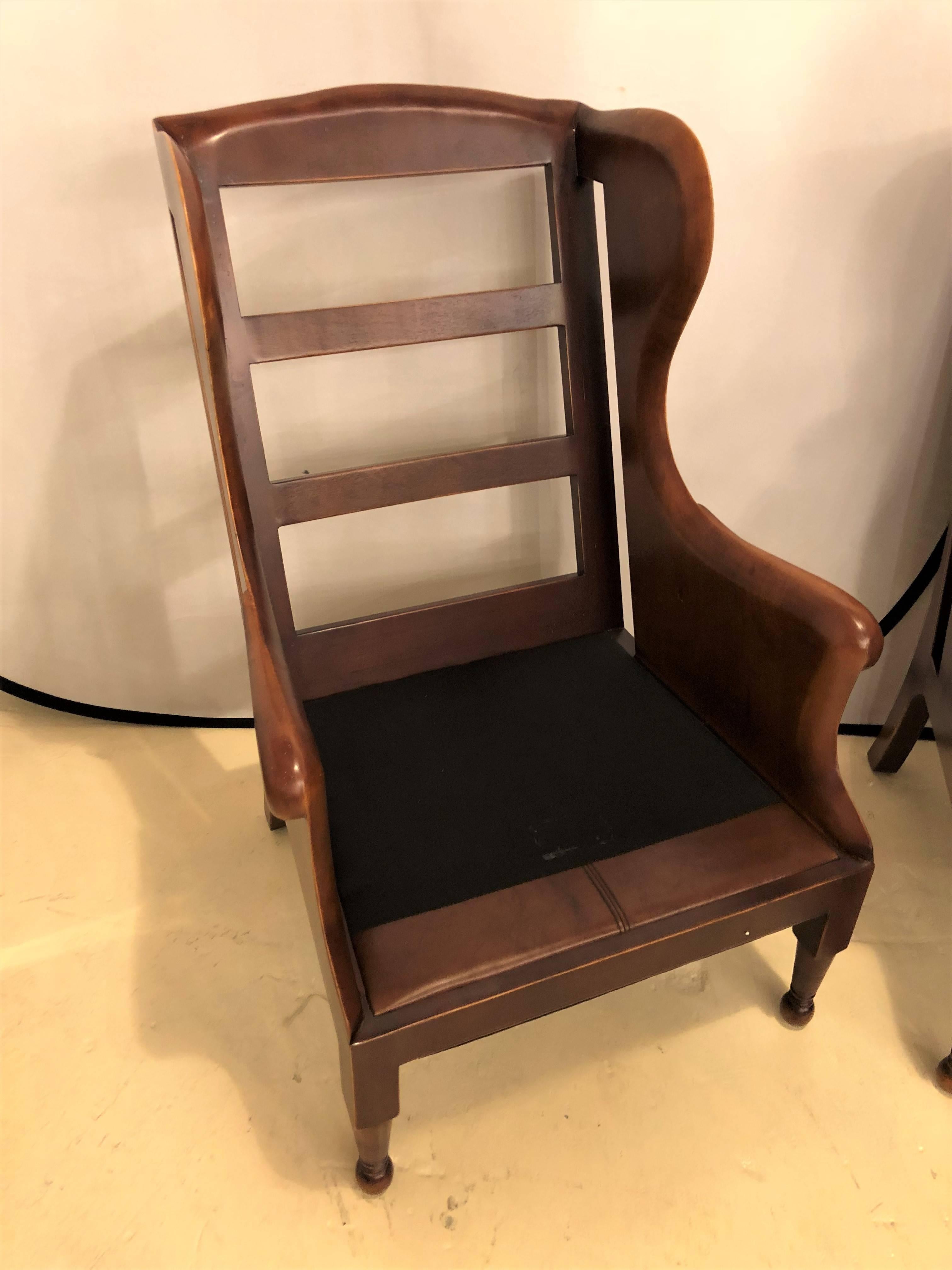 A pair of fine leather lounge or bergere chairs. Both having solid wooden framed in the ladder back style with cushioned leather seats and backrests.