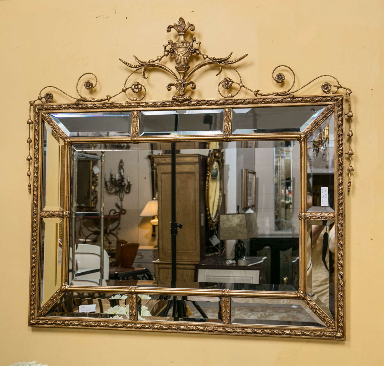 Adams style beveled mirror in a finely carved frame. The central beveled mirror flanked by a group of ten beveled framed mirrors set in a wooden carved and gilt border. The outer wooden carved and gilt border terminating in a wonderfully decorative