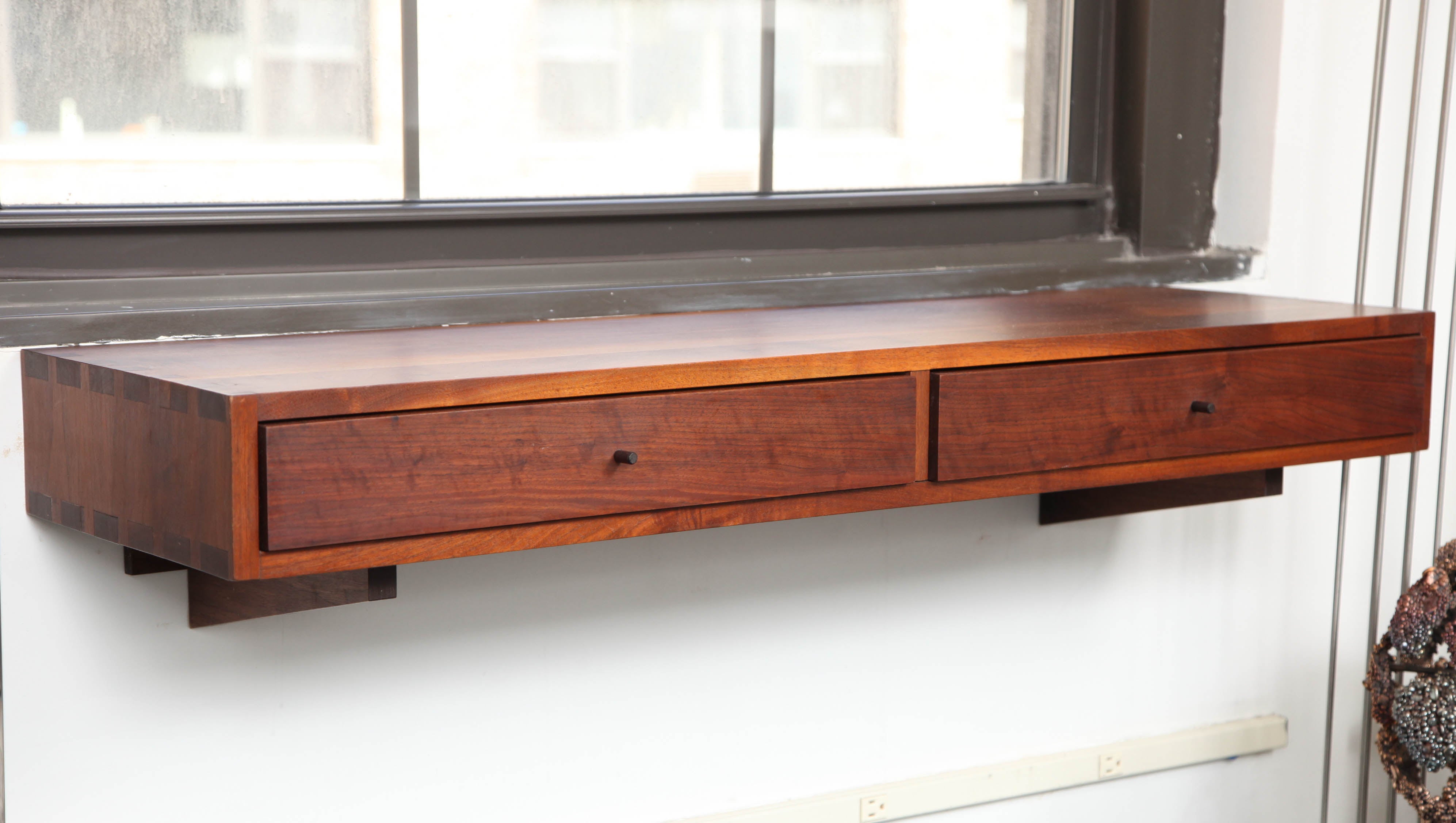 Studio wall shelf made of walnut with two drawers and rosewood pulls. Don Dean made this piece in 1962 while he was attending the School for American Craftsman at Rochester Institute of Technology in Rochester, NY. His professor was Tage Frid and