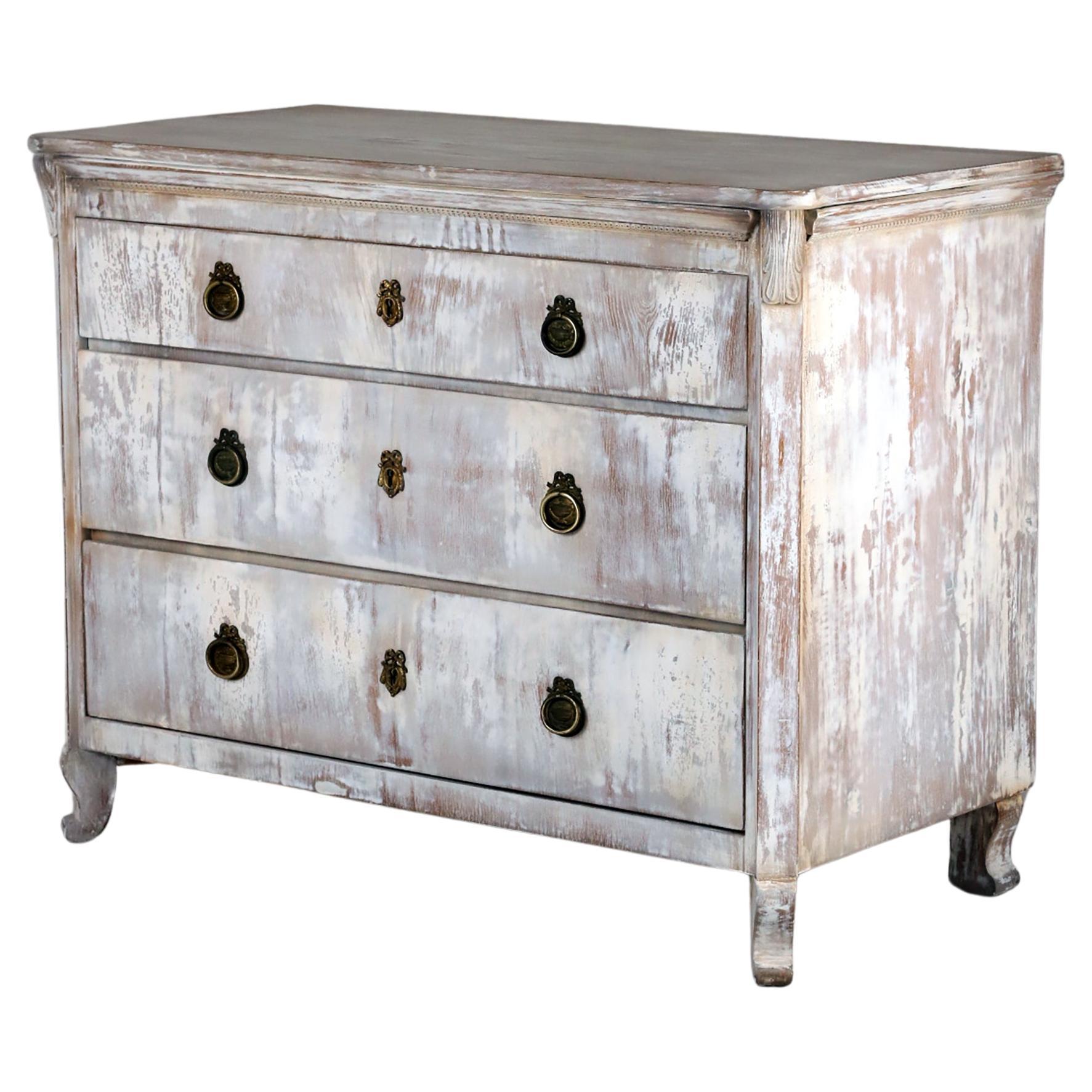 19th Century Gustavian Style Chest of Drawers, 
Germany, 1850
Ashwood

A decorative Swedish Gustavian style chest of drawers made of solid ashwood, three drawers with brass hardware. Three locks with three keys. 
Nice form with decorative ornaments