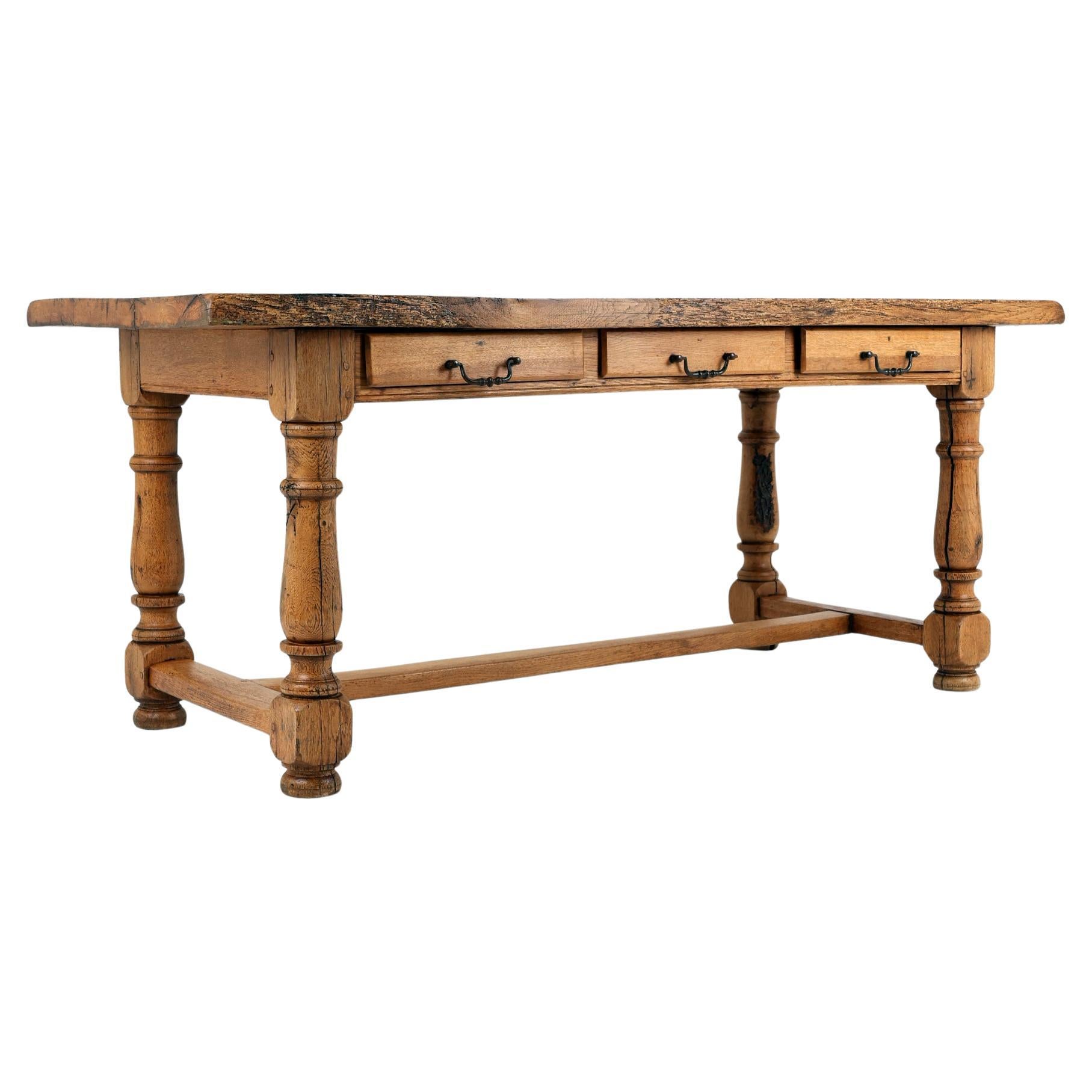 Table de salle à manger en chêne massif du XIXe siècle 
France, 1800-1820
Chêne massif

Table de cuisine ou de salle à manger ancienne en chêne massif avec une superbe patine. Le plateau massif en planches de 5 cm d'épaisseur repose sur des pieds