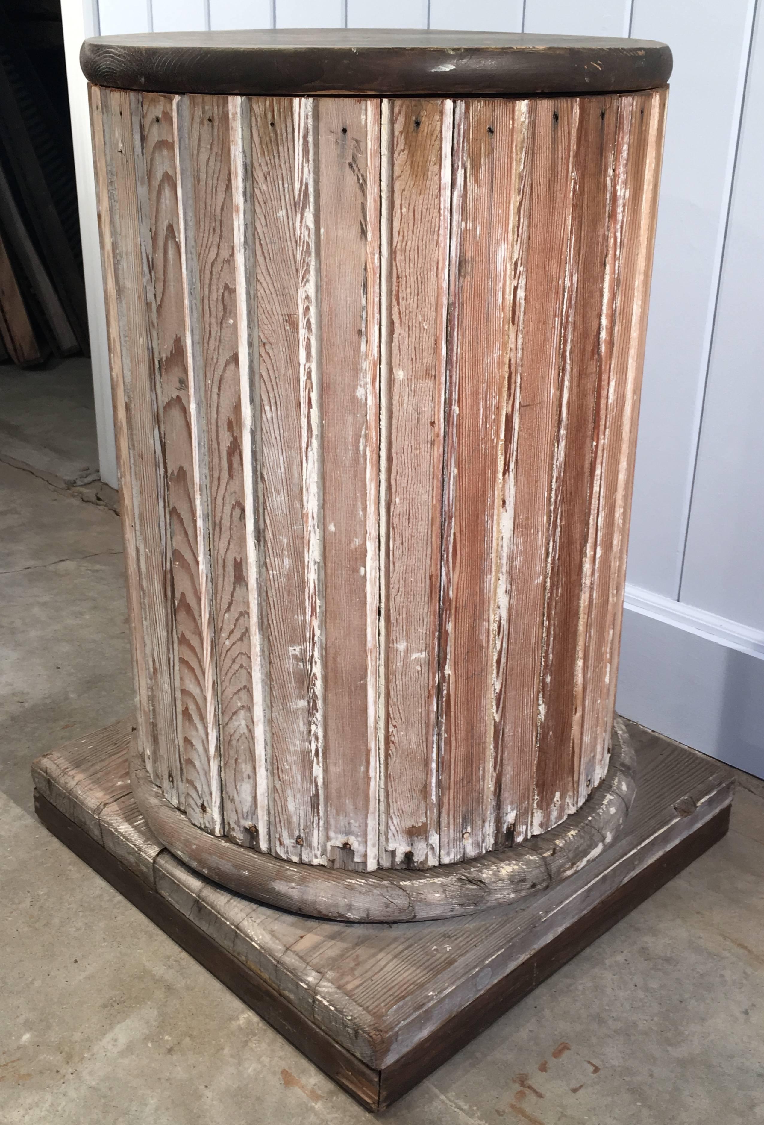 This handmade round wooden pedestal with square foot has a lovely scraped paint surface and the size makes it extremely versatile for holding a large pot, statue or urn. In fact we have had pieces that weigh over 200 pounds on it. In good condition,