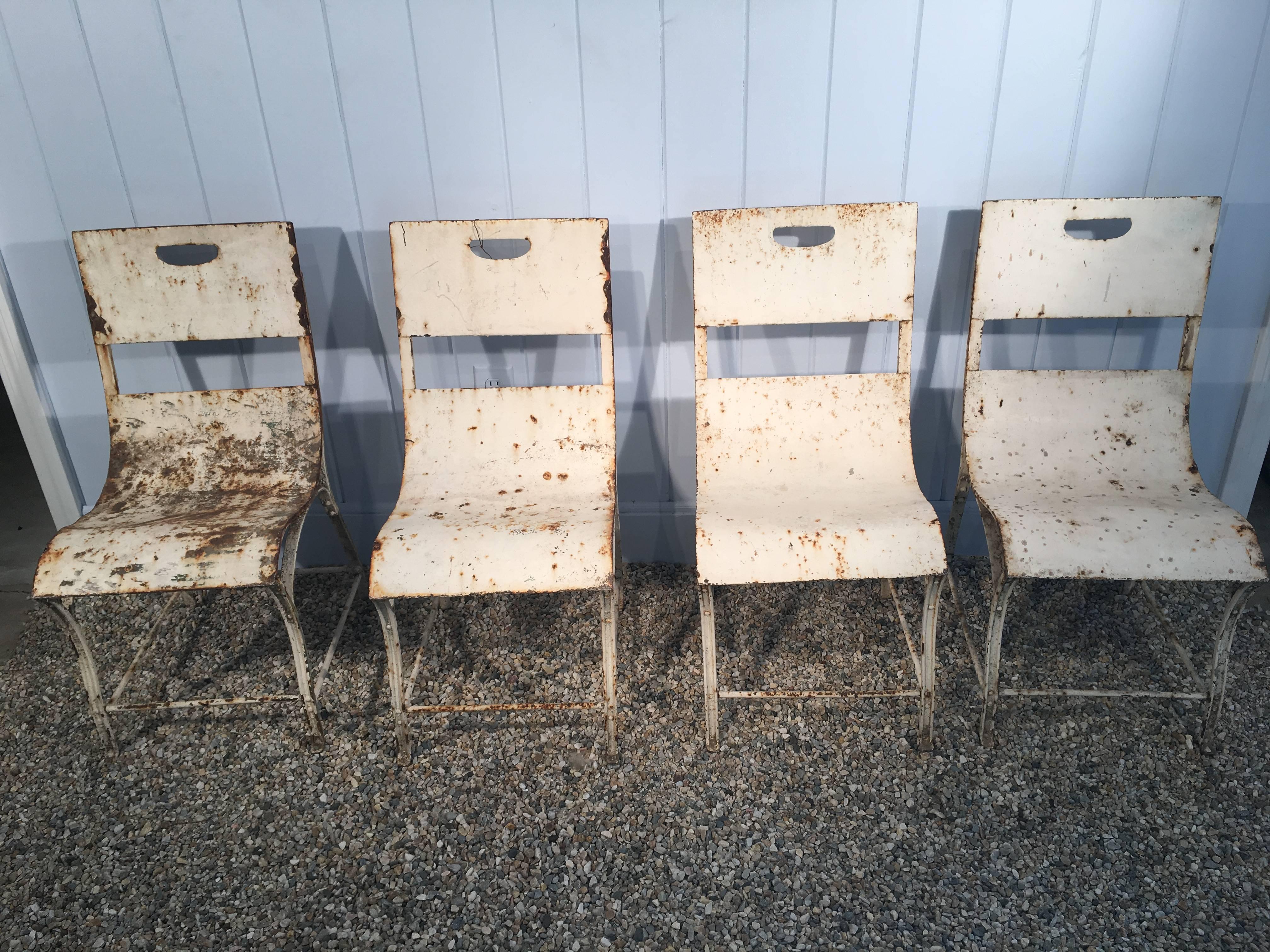 A great set of very comfortable sinuous steel garden chairs, French, circa 1930. Weathered white paint, but we can have them sandblasted and repainted for a modest upcharge. Excellent condition. Please note that we have a set of eight chairs,